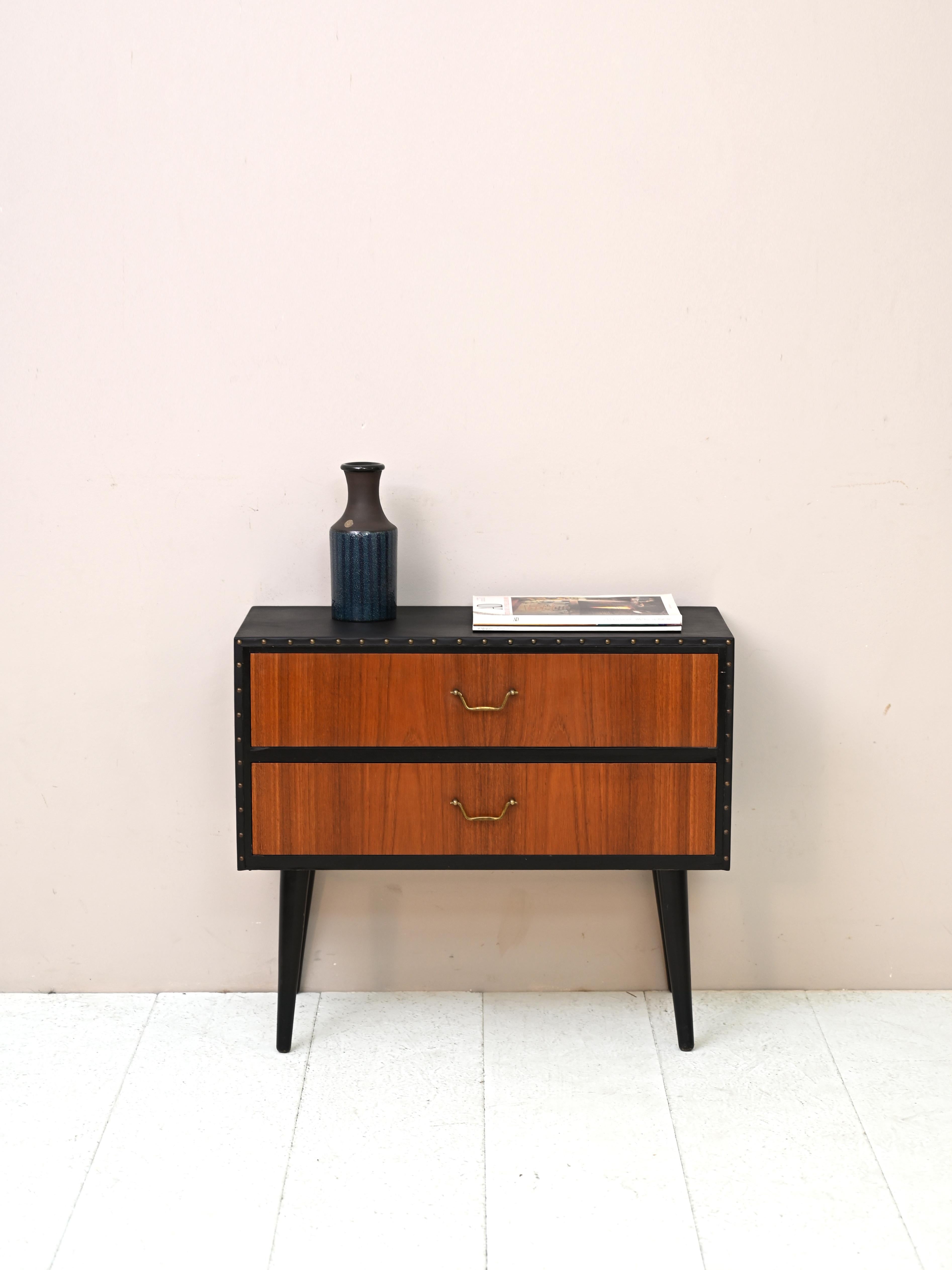 Particolare mobile di origine scandinava con due cassetti.

Presenta un rivestimento in similpelle nera sul piano e sui lati. 

Un pezzo di design originale, ideale per dare carattere a una camera da letto o a un ingresso.

Buone condizioni. È