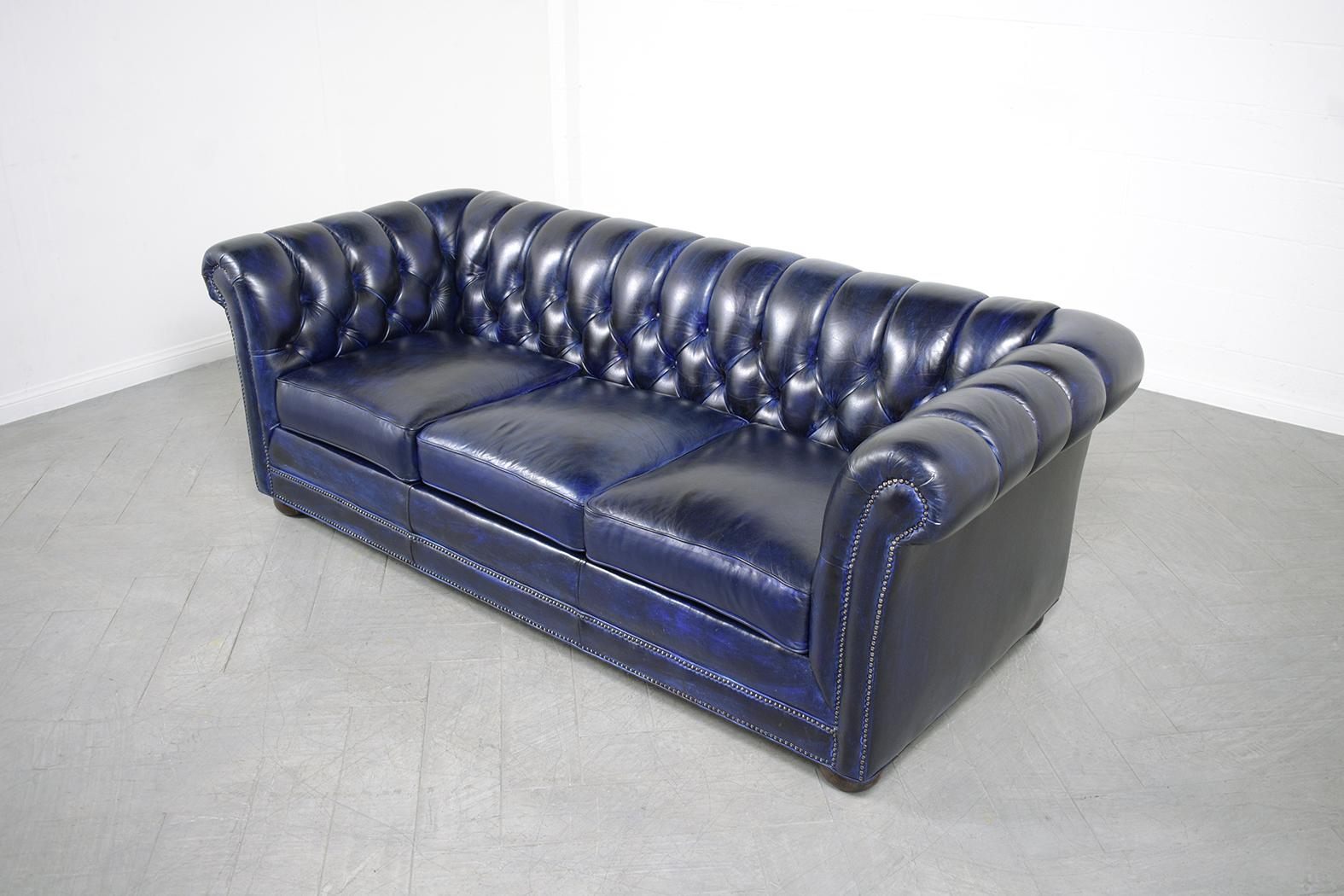 An extraordinary vintage navy blue leather color tufted chesterfield sofa in great condition the frame is crafted out of solid wood and has been completely restored by our professional craftsman team in the house and has been newly dyed in a custom