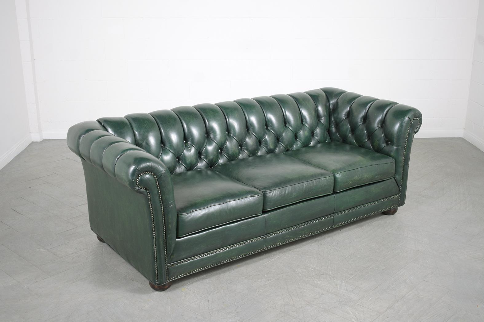 An extraordinary vintage green leather tufted chesterfield sofa in great condition the frame is crafted out of solid wood and has been completely restored by our professional in-house craftsmen team and has been newly dyed in a custom dark green