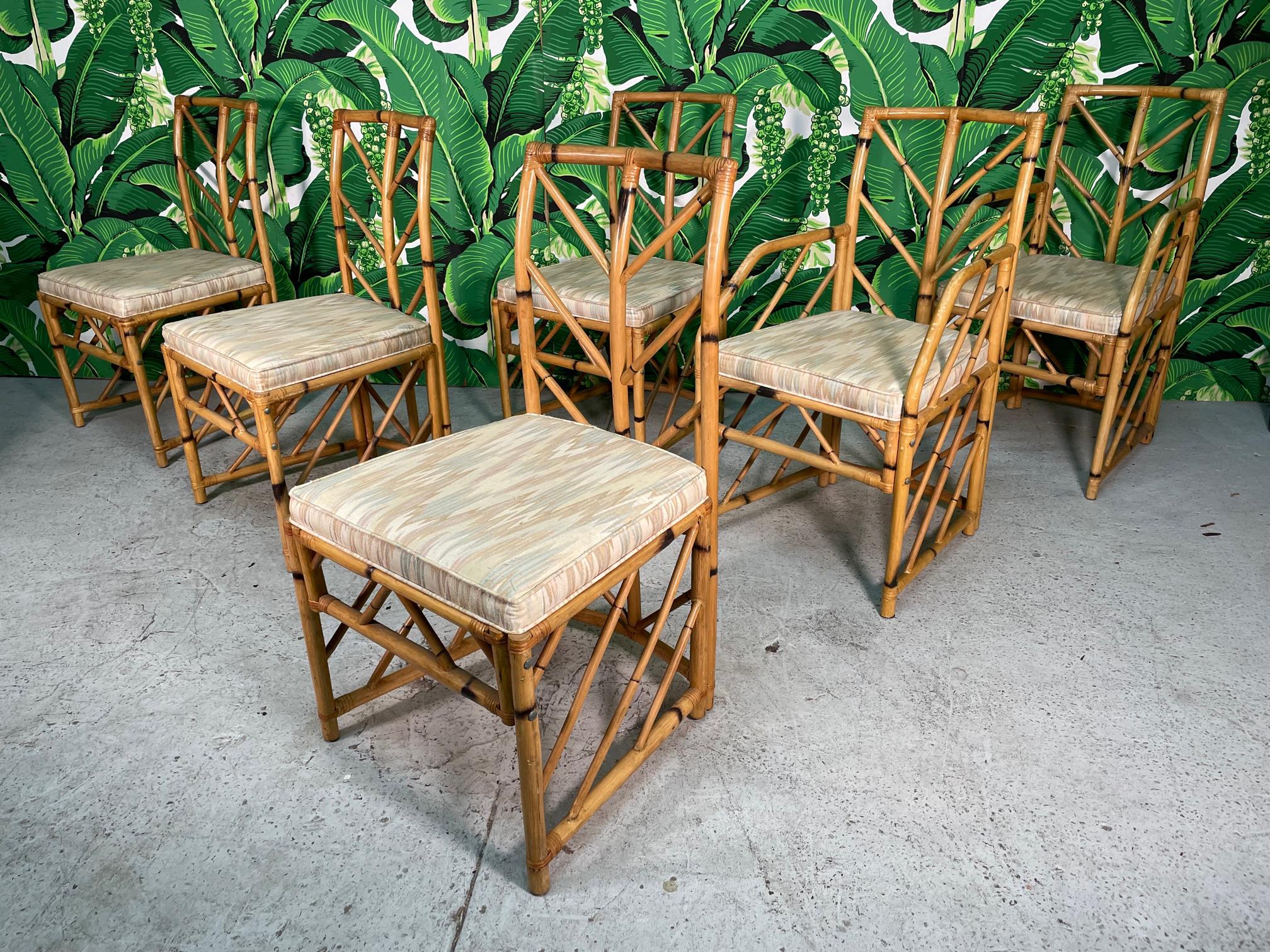 Set of six rattan dining chairs feature a unique chevron pattern fretwork. Set consists of two arm chairs and four side chairs. Good condition with minor imperfections consistent with age, mainly on arms. See photos for condition details.
For a