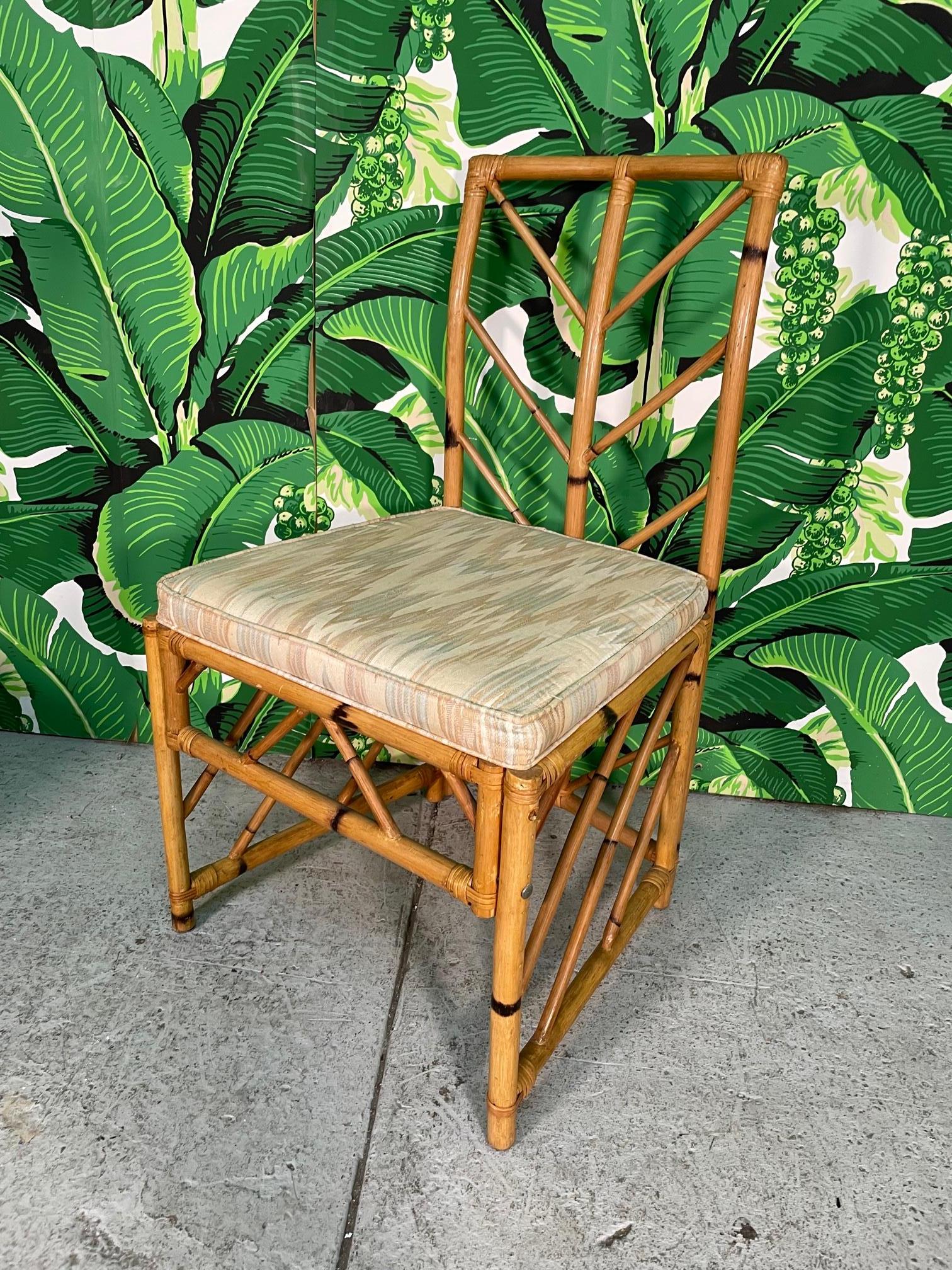 Set of six rattan dining chairs feature a unique chevron pattern fretwork. Set consists of two arm chairs and four side chairs. Very good condition with minor imperfections consistent with age, mainly on arms.

        