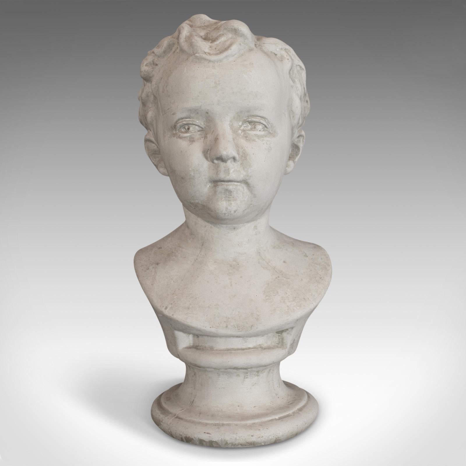 This is a vintage child portrait bust. An English, plaster cast study of a young boy and dating to the late 20th century.

Full of character and charm
Displays a desirable aged patina
Impish look captures the essence of a mischievous child
Wavy