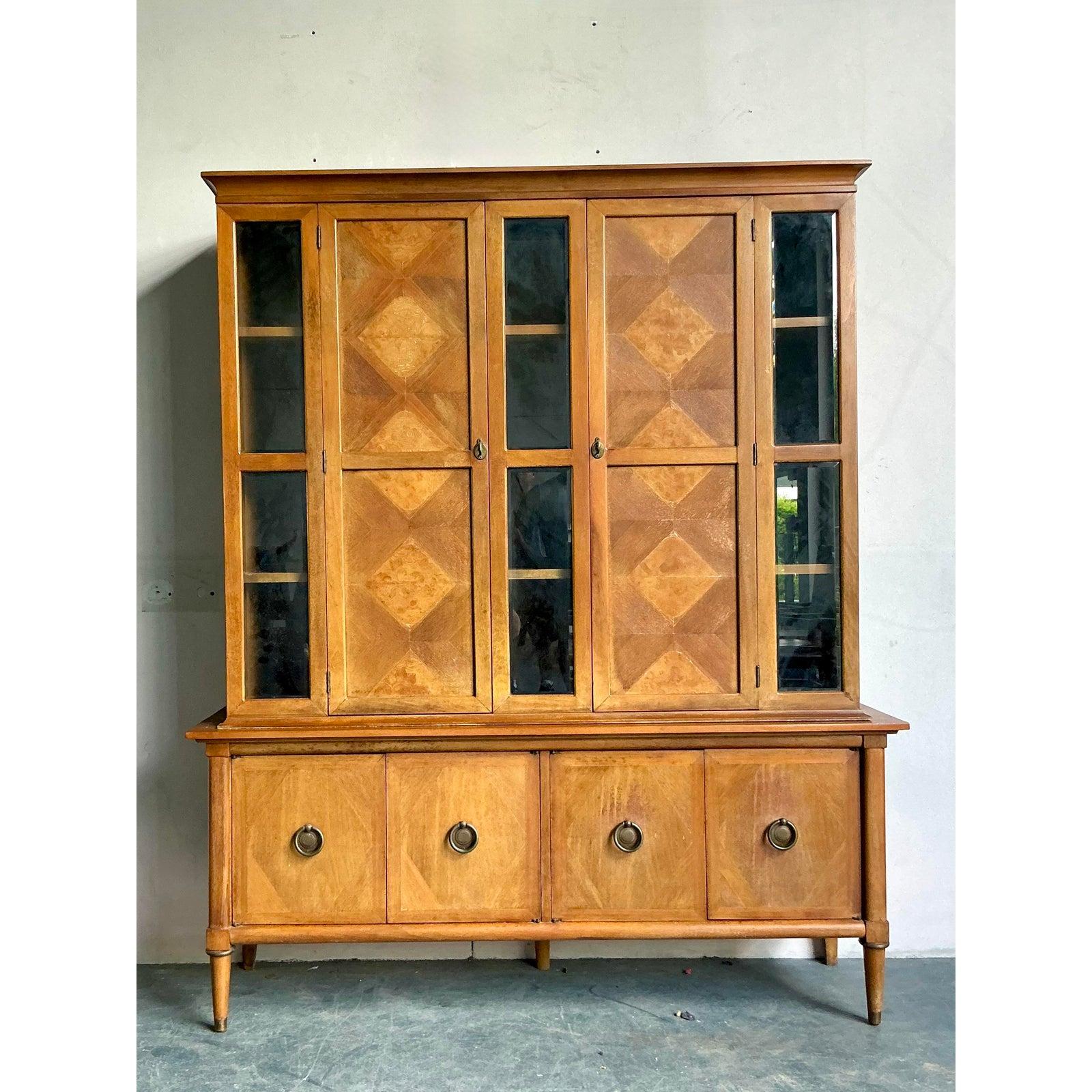 Eleva i tuoi interni con questa eccezionale credenza vintage della rinomata American of Martinsville, una masterclass nel design del Mid-Century Modern. L'elemento distintivo del mobile è l'accattivante parquet in radica diamantata delle ante