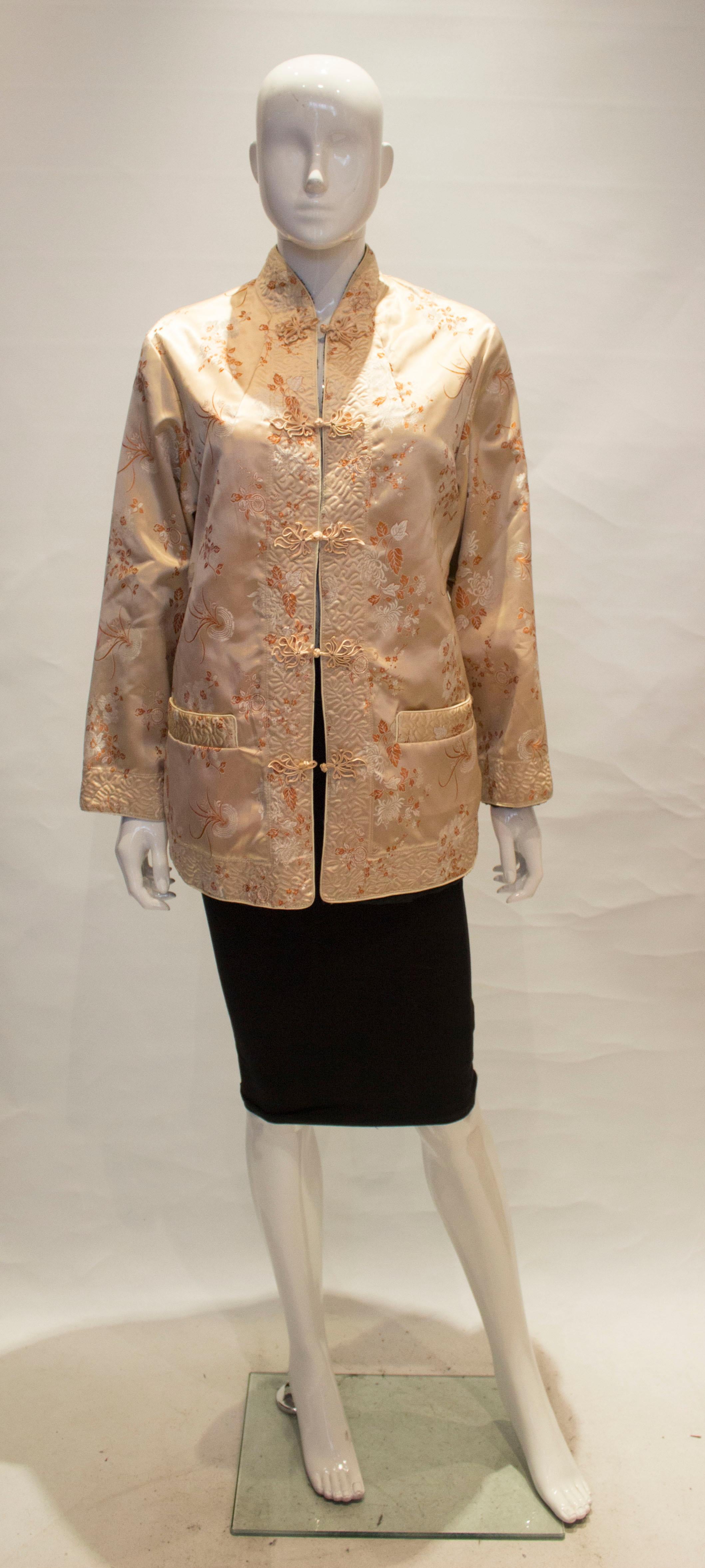 Eine hübsche Vintage-Chinease-Jacke in zartem Gold mit orangefarbenen Details und schwarzem Pelzfutter.
Die Jacke hat einen Stehkragen, Taschen auf beiden Seiten und einen 5''-Schlitz auf jeder Seite.
