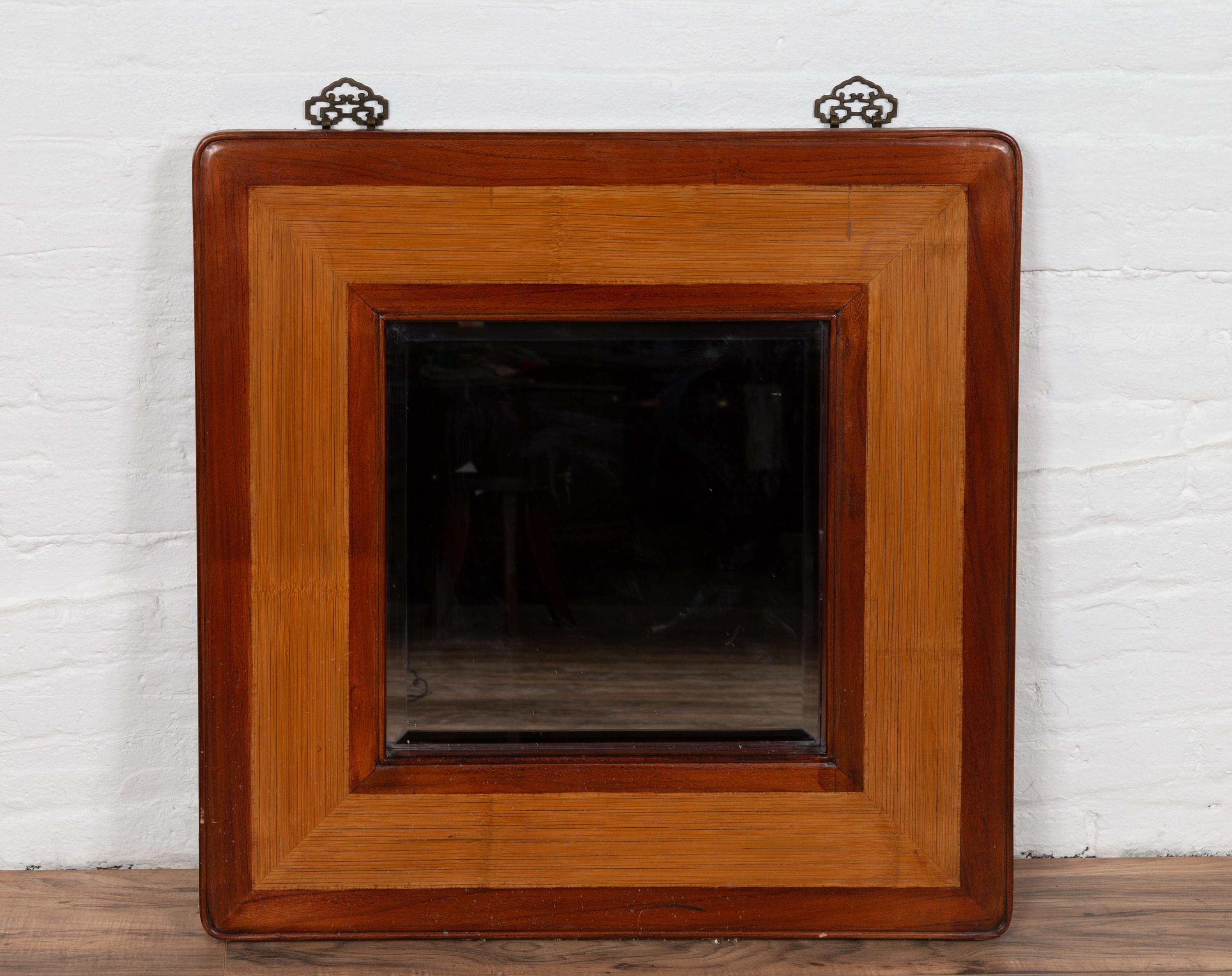 A vintage Chinese square mirror from the mid-20th century, with beveled glass, elm frame and rattan accents. Born in China during the mid-century period, this charming mirror features a simple square silhouette, accented with the two-toned contrast
