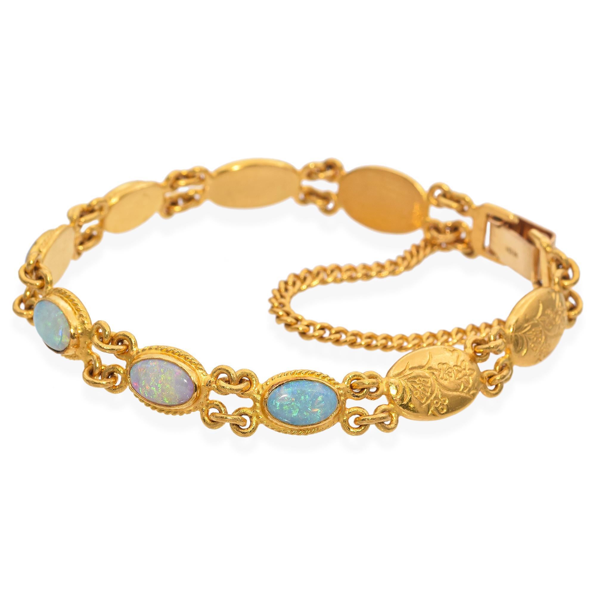 Elegant vintage bracelet crafted in 24K yellow gold. This exquisite piece features opal gemstones set in oval bezels, each linked by intricate gold connectors. The bracelet is secured with a sturdy clasp and includes a safety chain for added