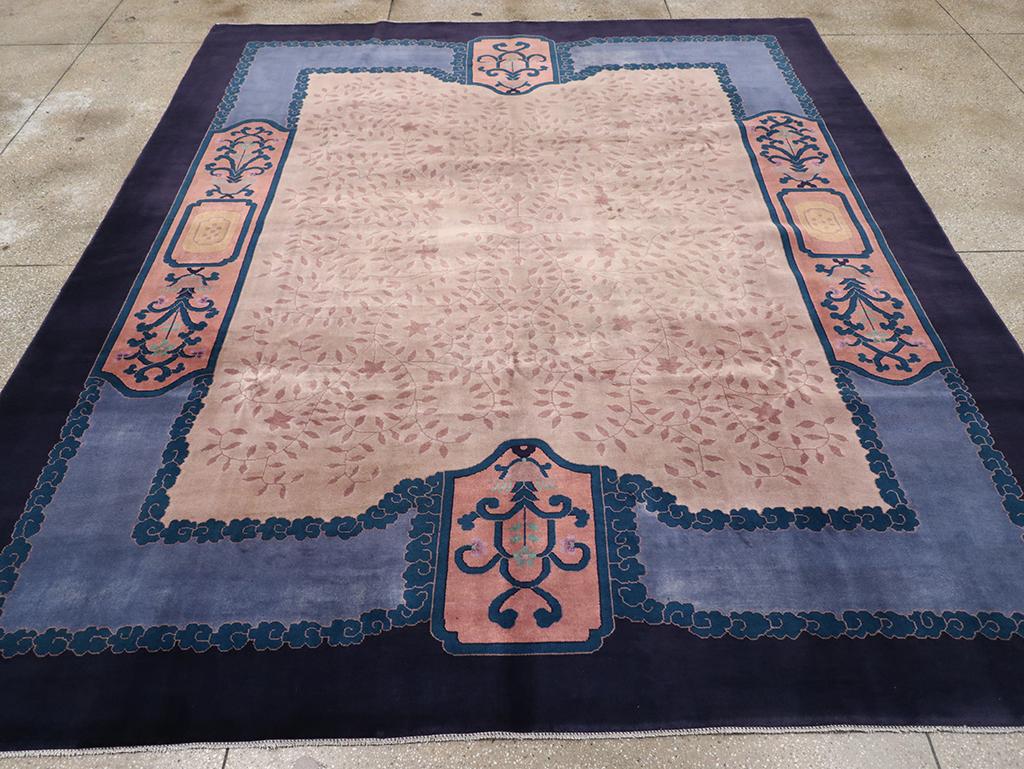Esta alfombra Art Déco china de mediados del siglo XX, que mide 3 m x 4 m, muestra un diseño refinado y sofisticado que mezcla motivos chinos tradicionales con la elegancia del Art Déco. El campo central está adornado con un intrincado motivo floral