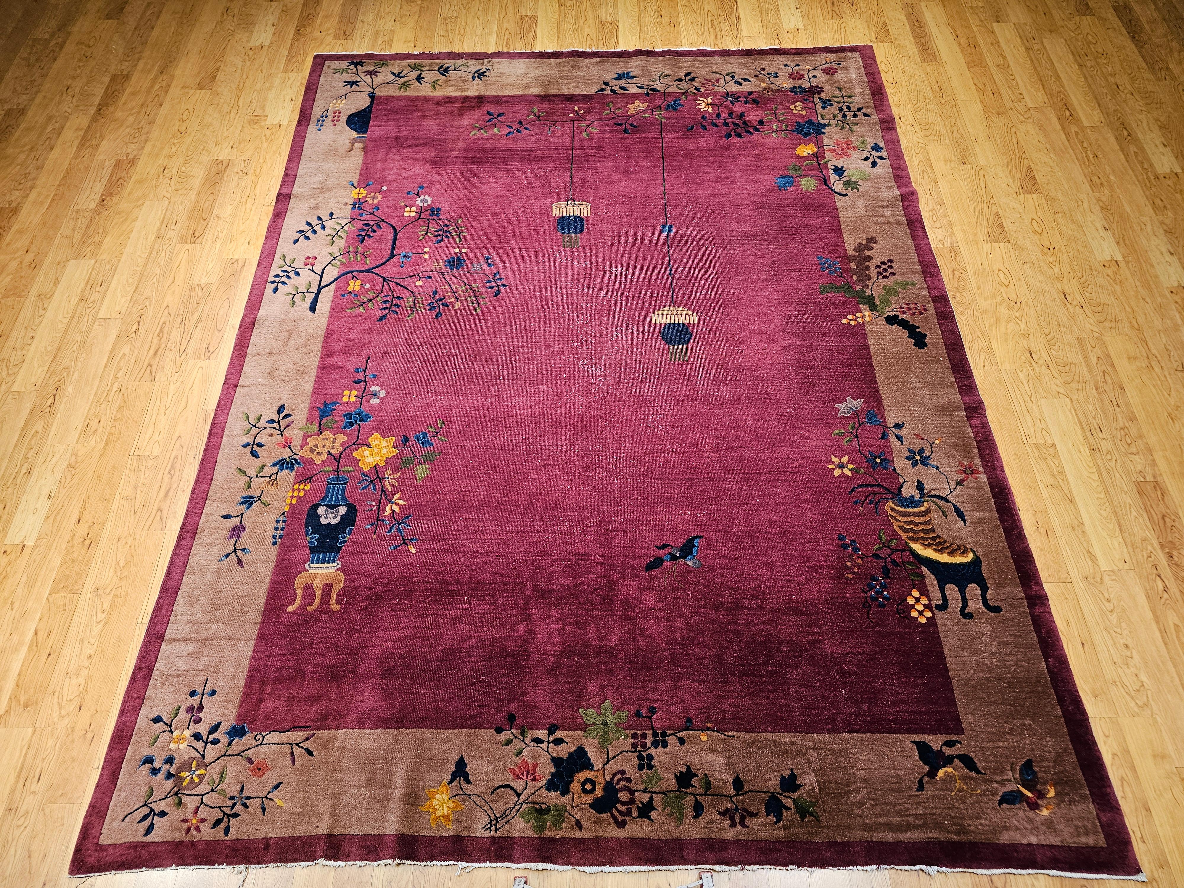 A stunning example of early 20th-century Chinese artistry, this vintage hand-knotted Art Deco rug from the 1900s features an exquisite floral and butterfly motif that radiates elegance and harmony. Set against a deep dark magenta field, the design