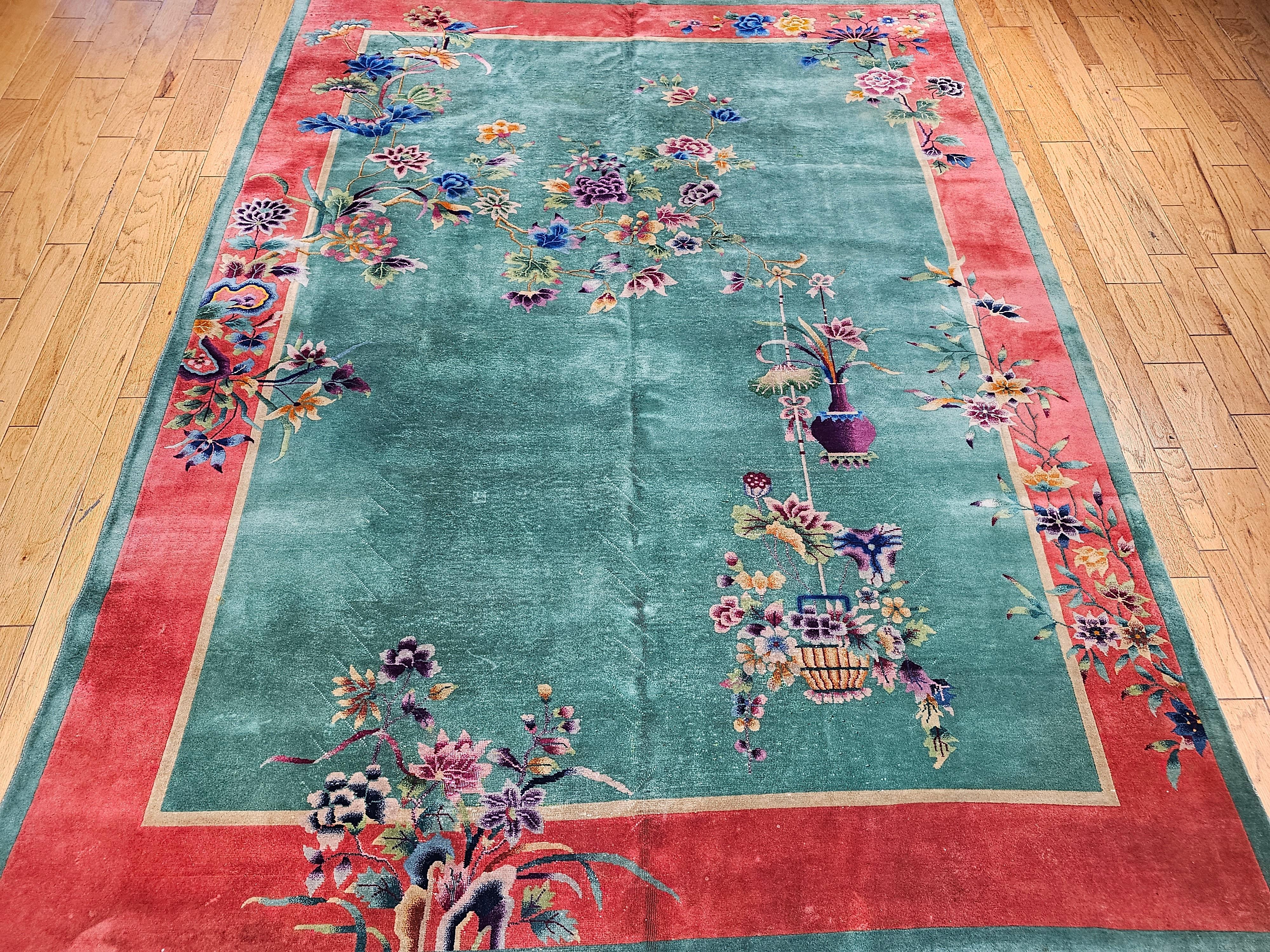 Breathtakingly Beautiful!  A hand-knotted Chinese Deco rug with a vase and floral design.  This rug has a beautiful green field with lush floral design perfusing throughout the field in purple, blue, red, yellow, and shades of those colors.    The
