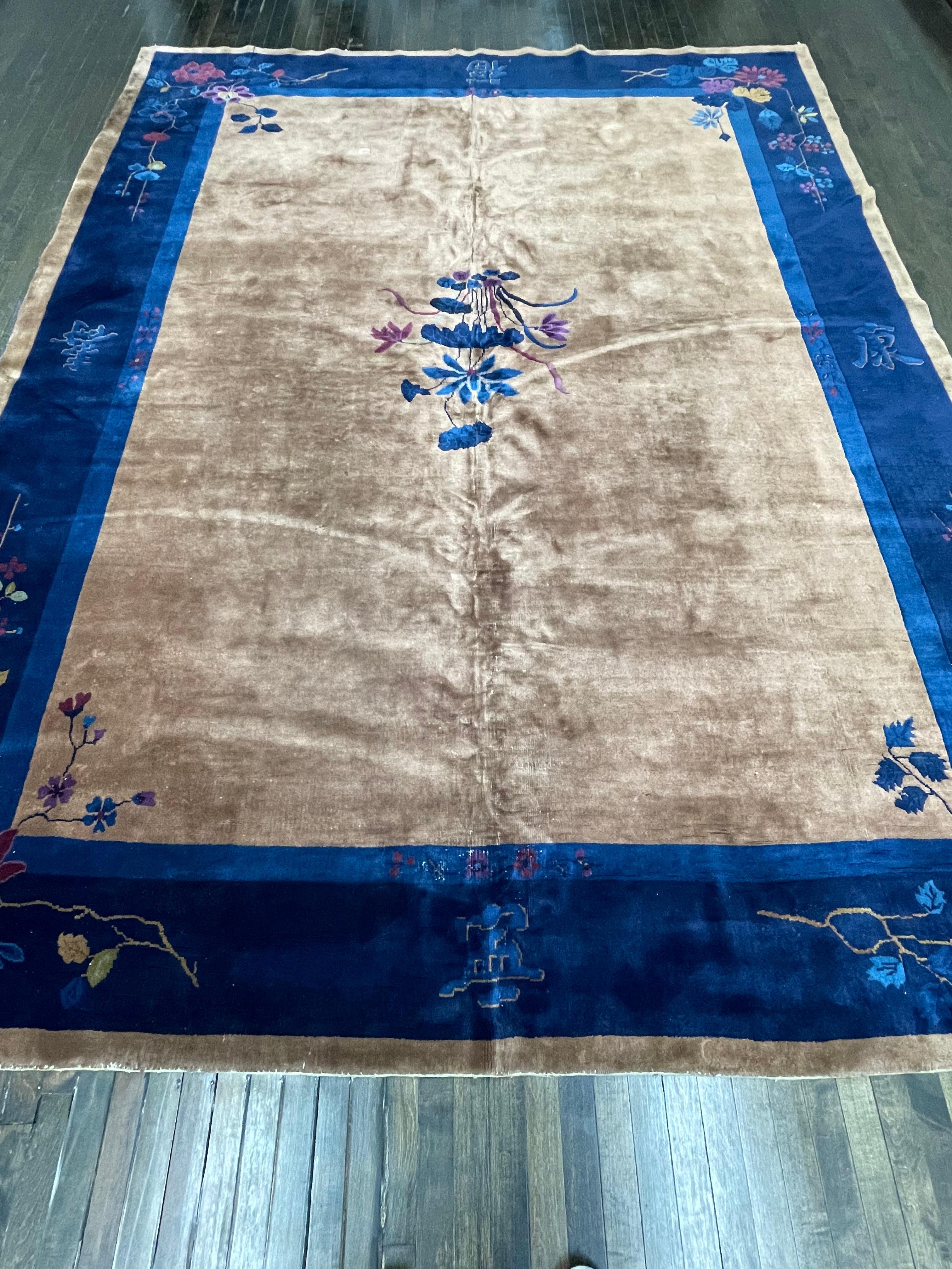 This carpet is hand knotted in China. Known as mainland Chinese these carpets were made with high quality wool and all organic dyes, which makes them age really well and develop a nice patina.

Having a tan/brown field with indigo blue border this