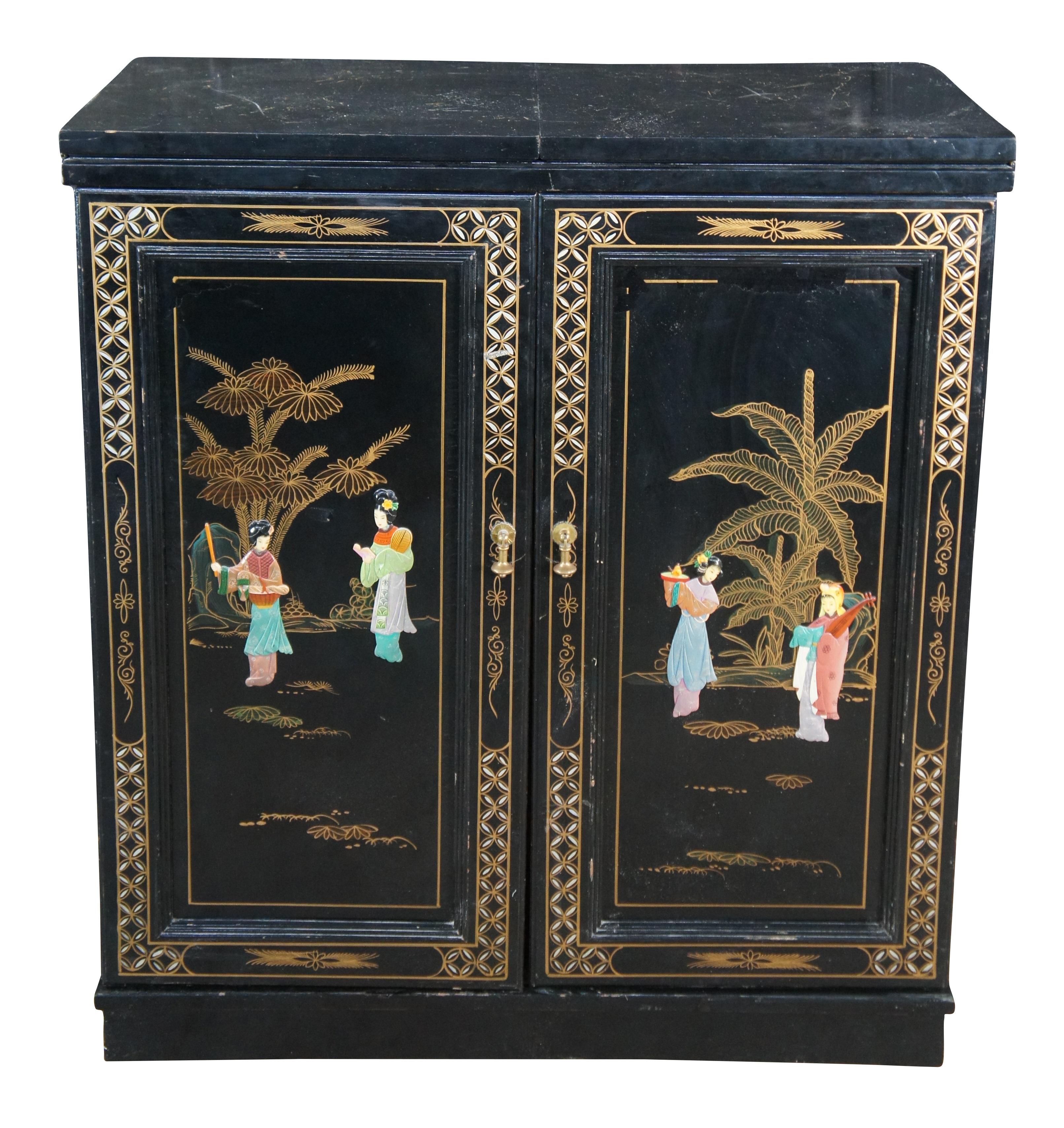 An Impressive Chinese Black lacquer folding bar cabinet, c.1970s  Features a black and gold exterior with hand painted garden scenes with soapstone geisha figures.  The cabinet doors open to support a marble inset flip top, revealing an impressive
