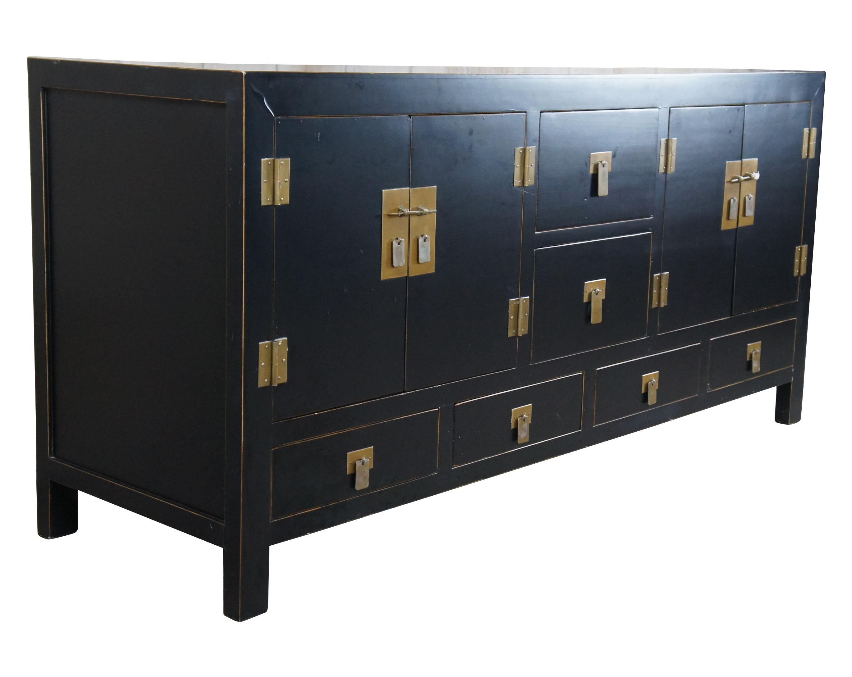 Late 20th century chinoiserie elm sideboard. Features a rectangular form finished in black with brass hardware. Includes two central drawers flanked by outer cabinets with interior shelves and four accessory drawers below. A versatile piece that