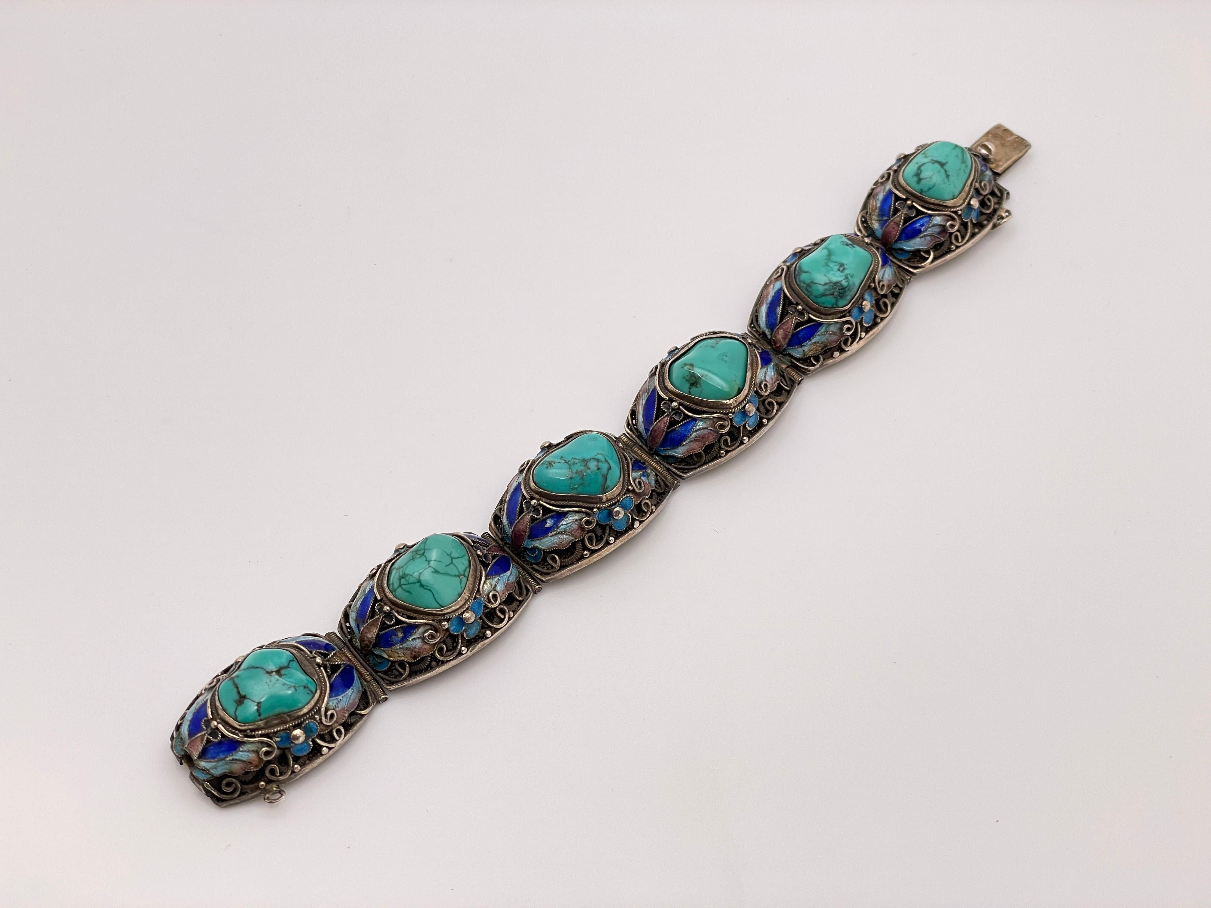 Un original collar de plata de ley antigua con esmalte de turquesa hecho a mano. Montado con un total de 6 cabujones naturales de turquesa azul/verde, cada uno montado individualmente en un engaste de plata con intrincados diseños de esmalte.

Con