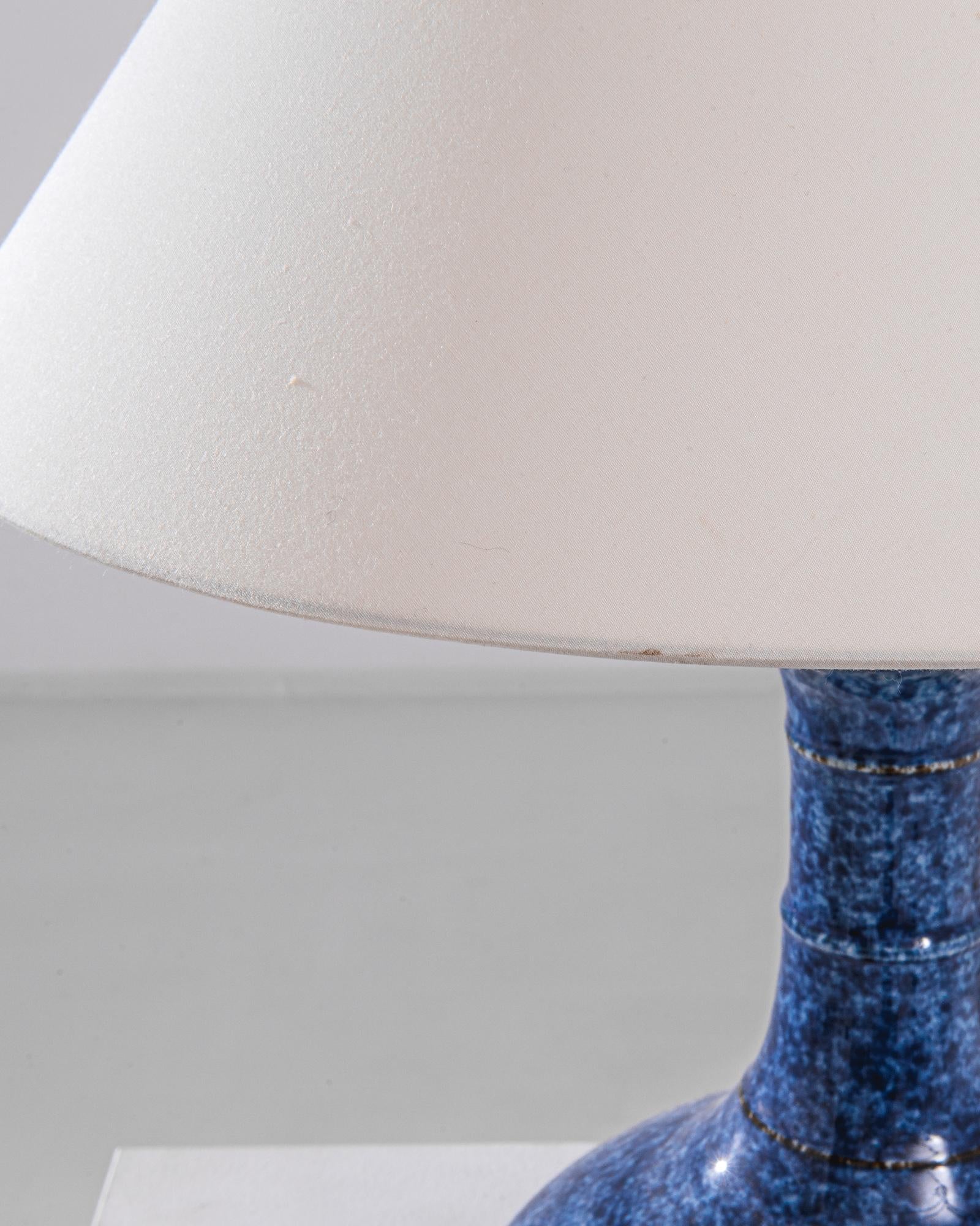 An extraordinary piece to inspire your collection. This vintage Chinese “garlic shape” vase has been adapted into a beautiful table lamp. Polished brass meets the speckled white and blue glaze, enlightening your space with an uncompromising