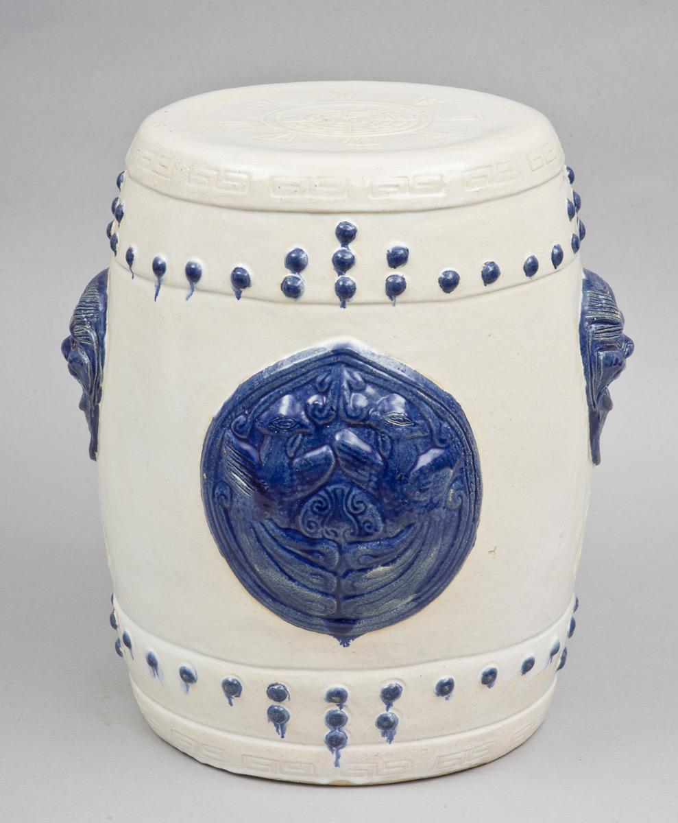 Chinese blue and white garden seat of barrel form decorated with open-mouthed masks with pierced openings below and pairs of birds on opposing sides, simulated raised nailheads all around.