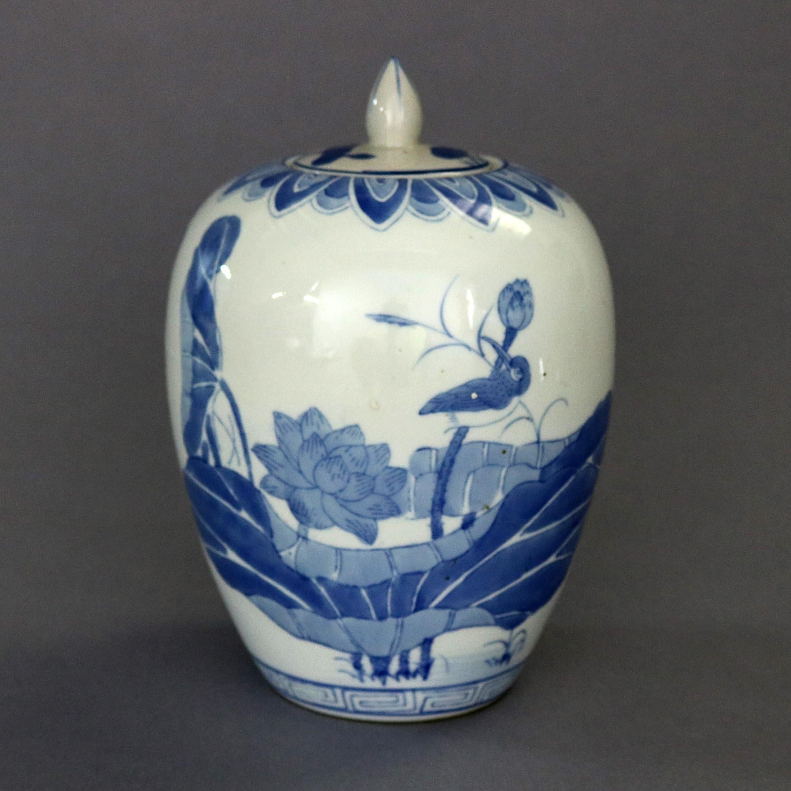 A vintage Chinese pictorial blue and white porcelain ginger jar offers hand painted marsh scene with flowers and birds, collar with repeating stylized leaf pattern and lower Greek Key bordering, 20th century

Measures: 10.25