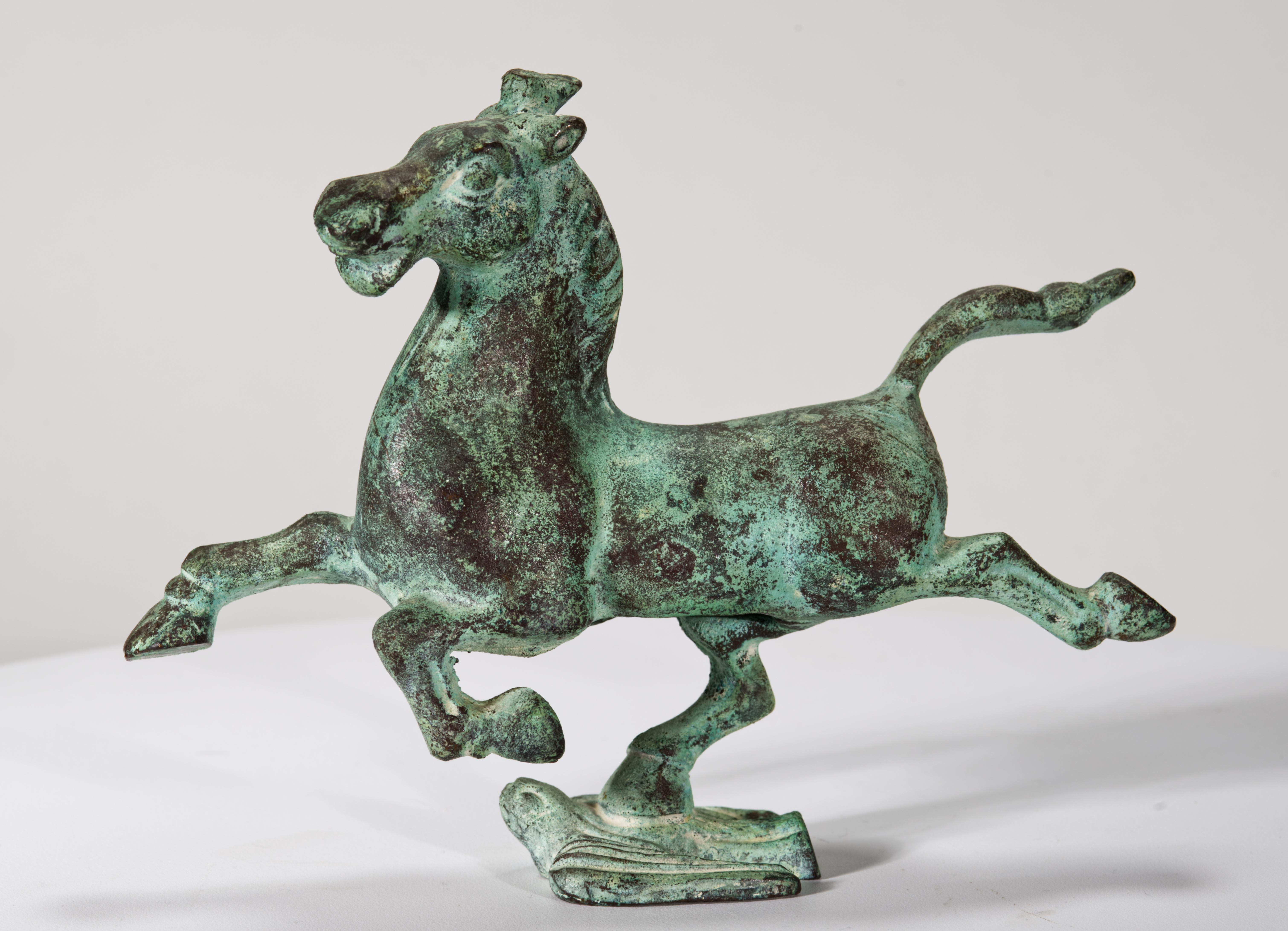  La scultura in bronzo d'epoca raffigura un cavallo al galoppo che calpesta un uccello in volo, con un'importante patina verde verdastra su una fusione molto dettagliata. La scultura è una replica del Cavallo Volante del Gansu, noto anche come