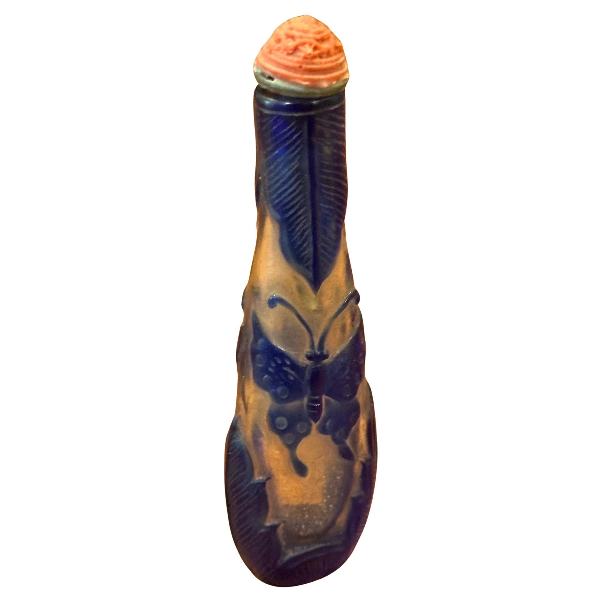 Flacon à priser en verre bleu à relief de papillon, d'époque chinoise, vers les années 1940.   La bouteille a une forme unique, haute et fine, et est en très bon état.  Cette bouteille est un merveilleux exemple de l'art sculptural chinois ; elle