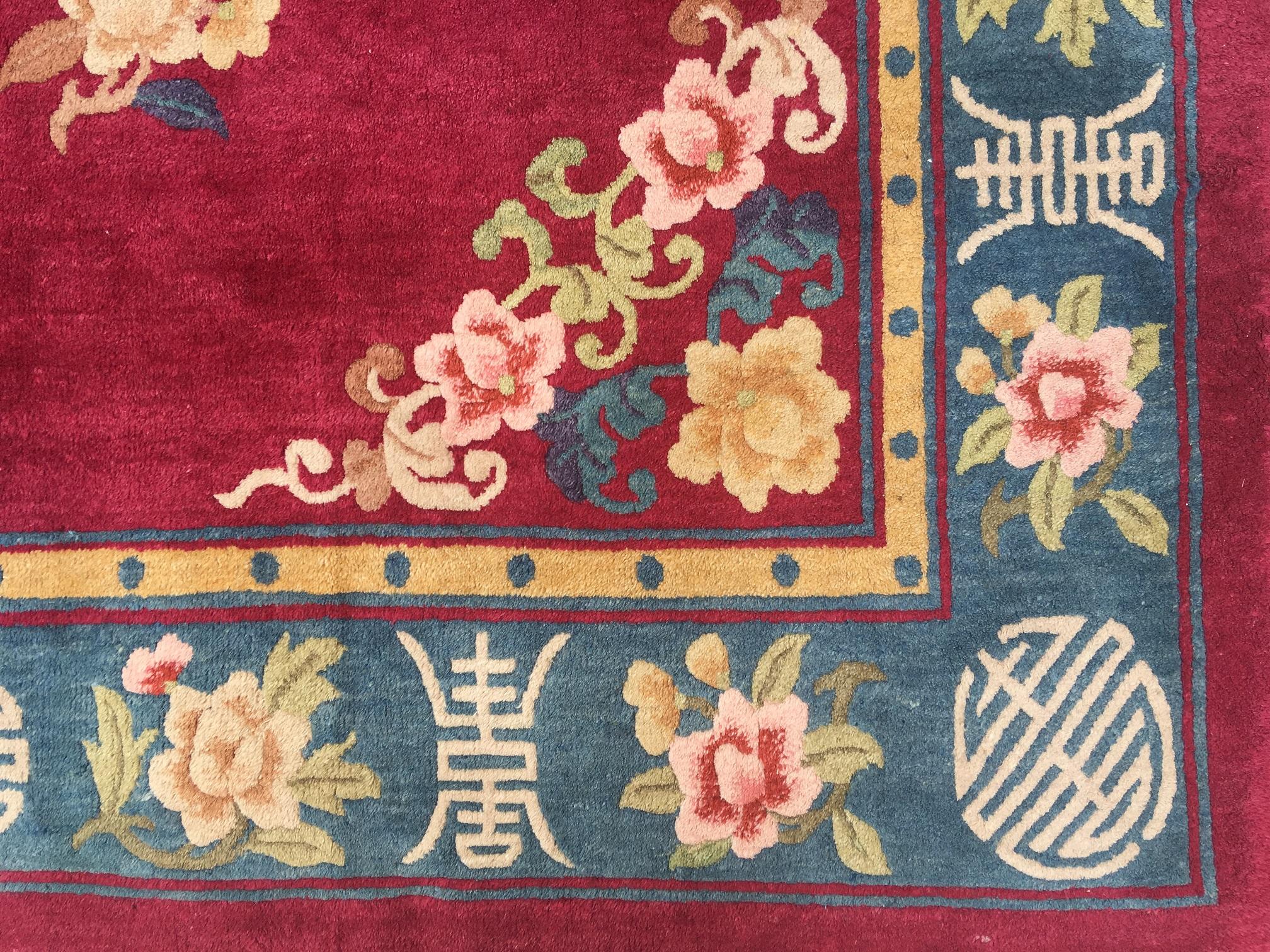 A beautiful Chinese carpet, handwoven circa 1960 with a design of flowers and bats (a symbol of happiness and joy!) on a rich ruby red field. Measures: 2.97 m x 2.14 m.