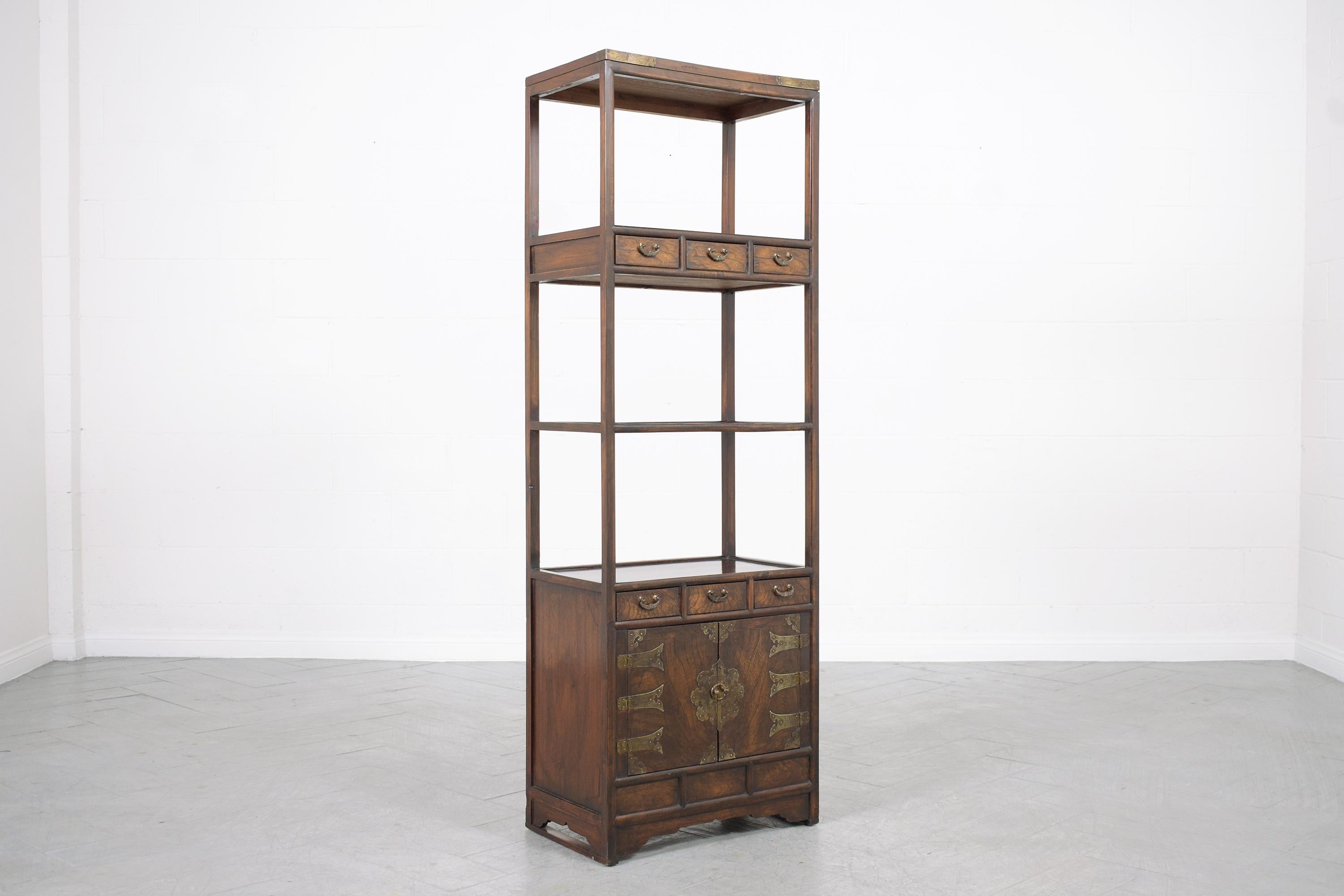 Discover the exceptional allure of our vintage Chinese bookcase, expertly handcrafted from resilient elm wood and fully restored by our professional team of craftsmen. In very good condition, this captivating bookshelf retains its original deep dark