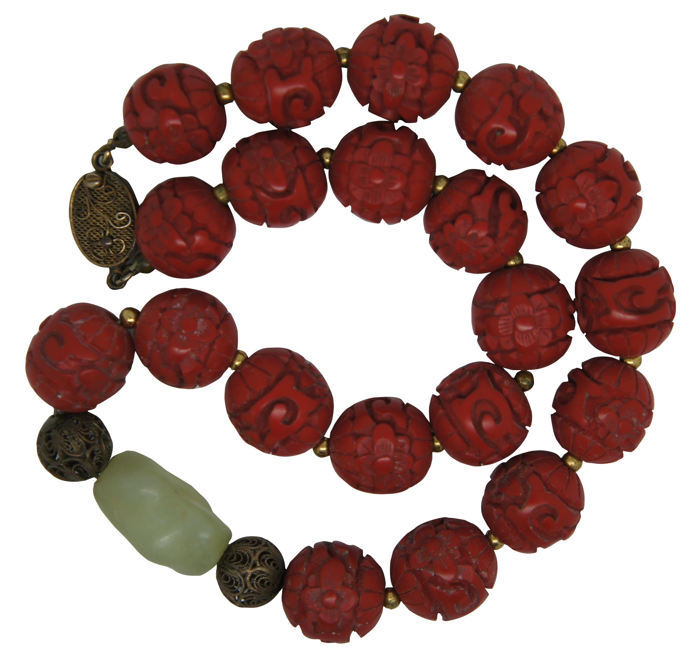 Vintage Chinese necklace of carved red cinnabar beads and a green jade accent bead with silver clasp. Measure: 16