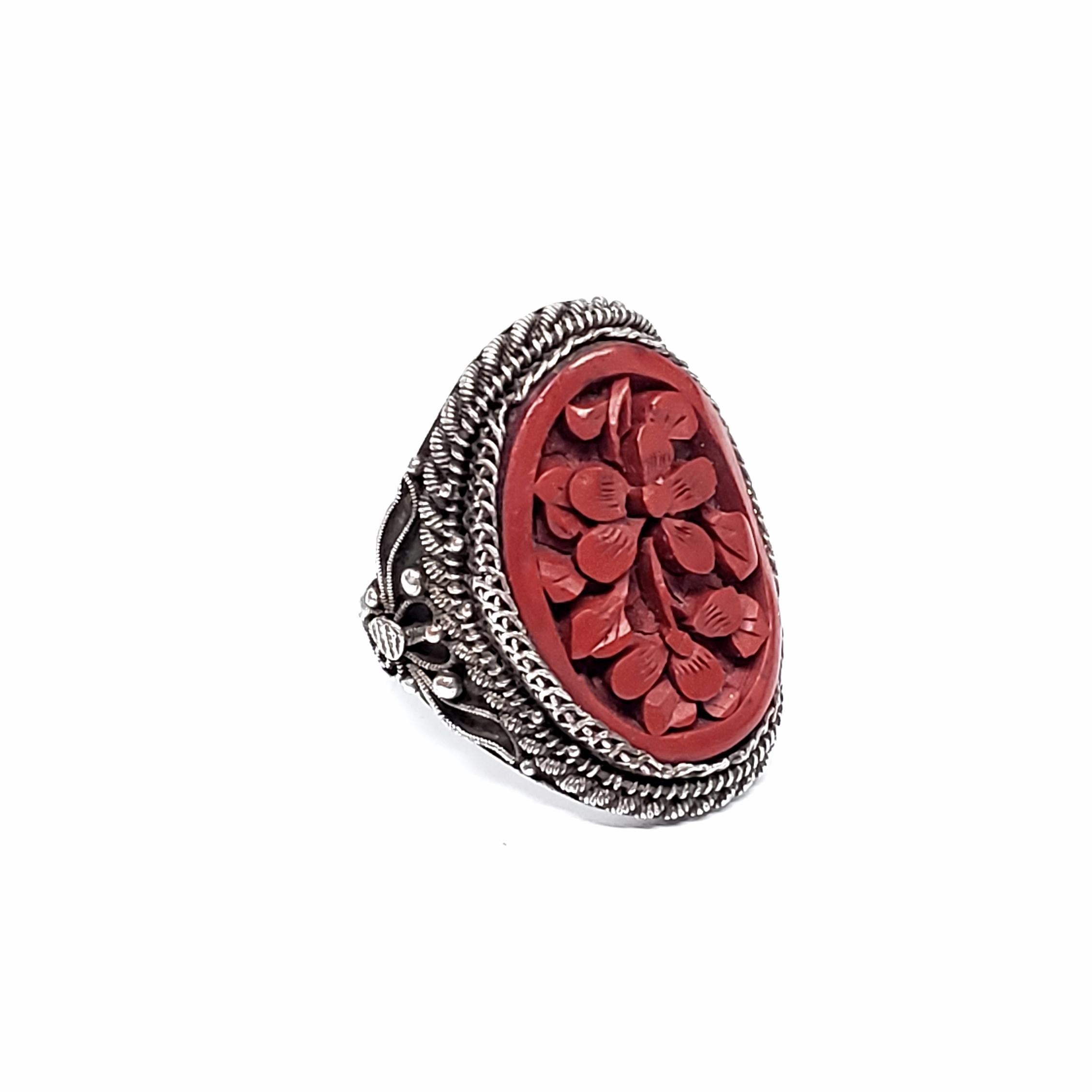 Chinese carved cinnabar ring, circa 1920s.

Beautifully carved cinnabar in a floral design, bezel set in a silver-toned ring with intricate detailing.

Measure 1