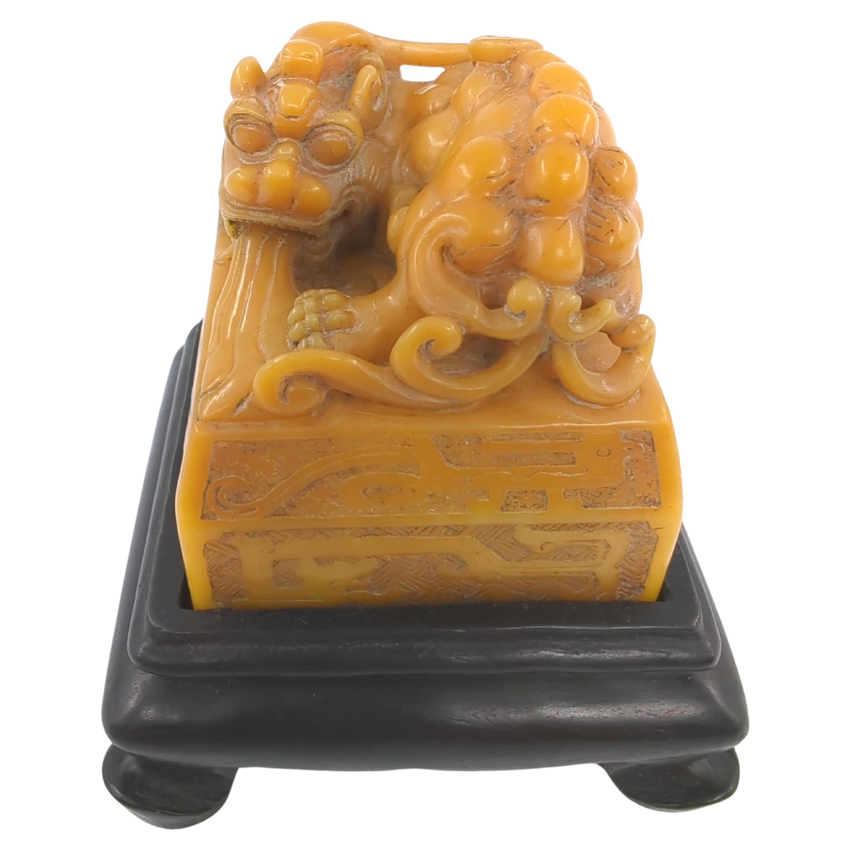 This vintage Chinese seal is an exquisite example of craftsmanship, intricately carved to feature a Pixiu, the legendary son of the dragon, perched majestically atop a square mound. The Pixiu is vividly depicted, complete with water flowing from its