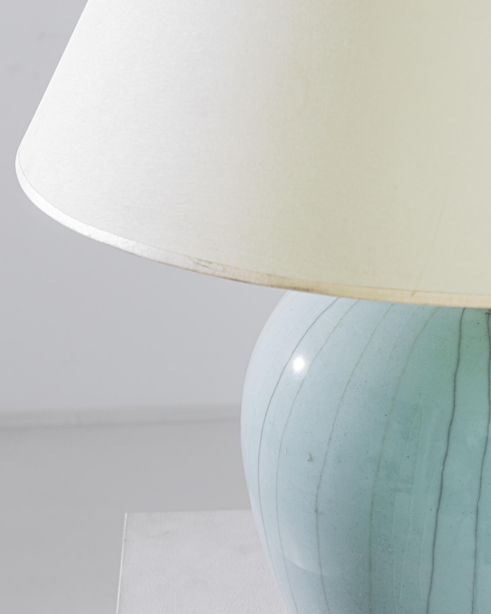An exceptional find to inspire your collection. This vintage Chinese storage pot has been adapted into a beautiful table lamp. Polished brass meets a beautiful celadon crackle glaze, enlightening your space with an uncompromising contrast. The