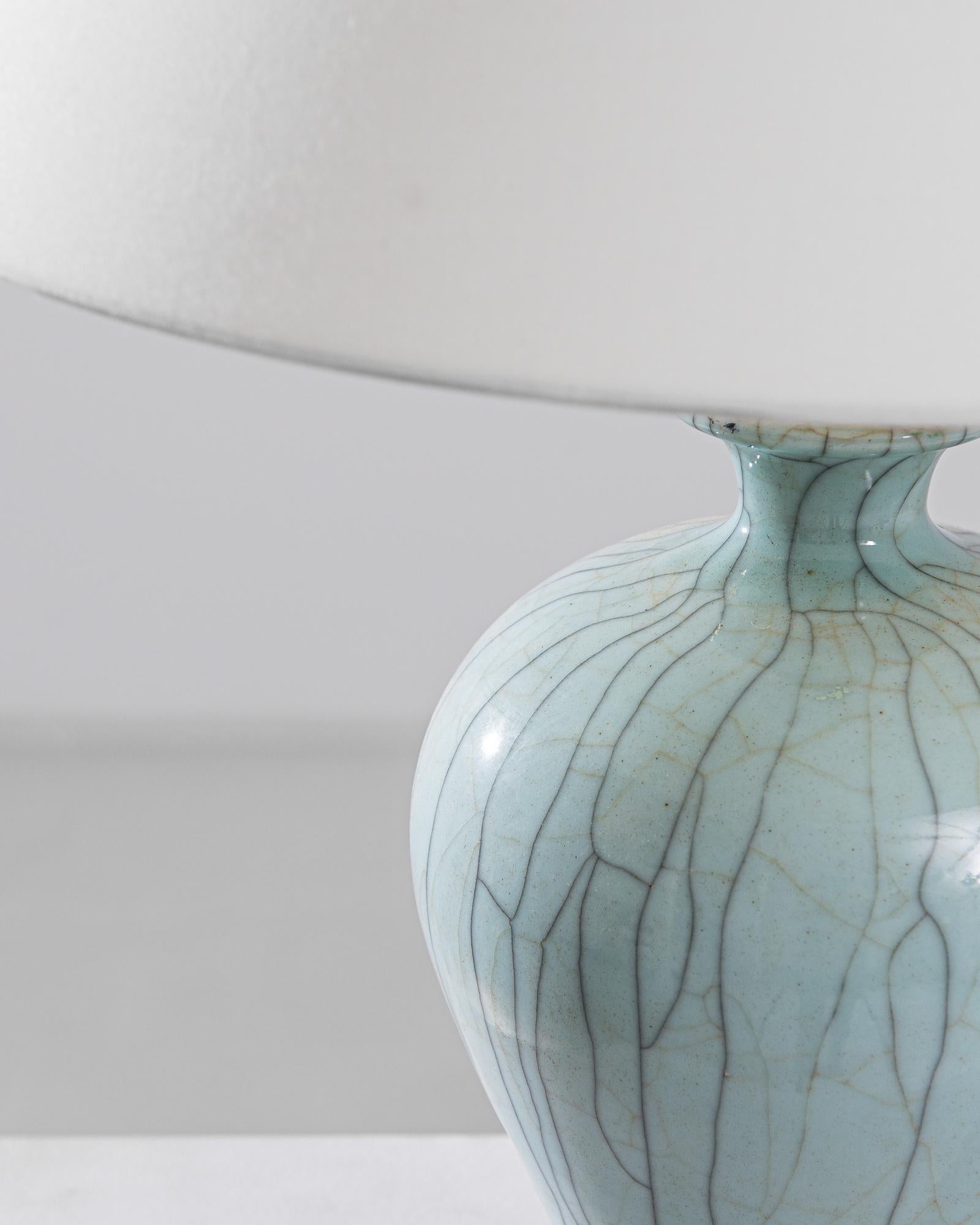 An exceptional find to inspire your collection. This vintage Chinese “plum vase” has been adapted into a beautiful table lamp. Polished brass meets a beautiful celadon crackle glaze, enlightening your space with an uncompromising contrast. The