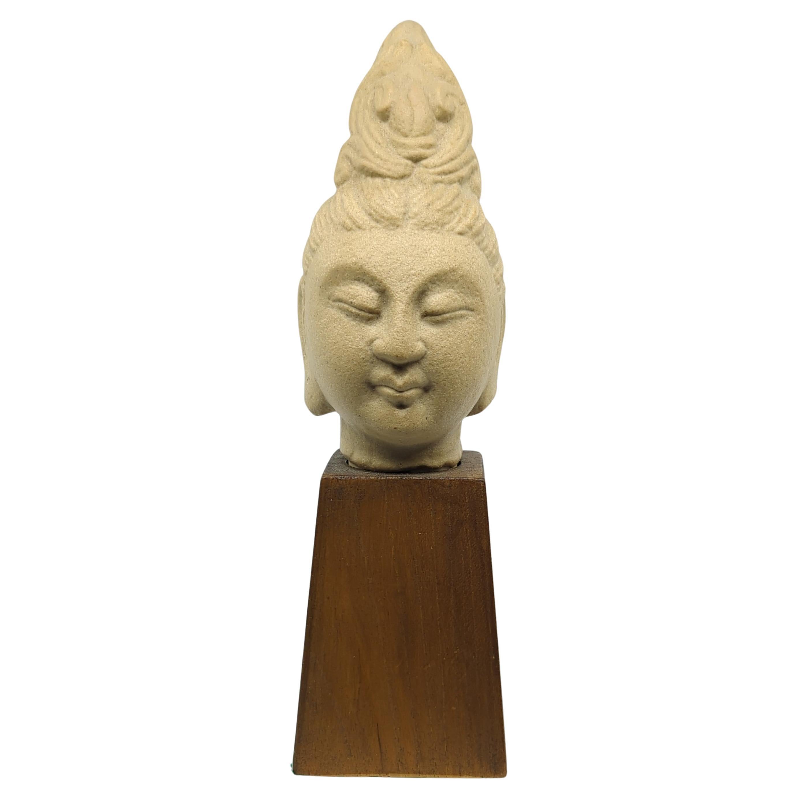 Diese chinesische Keramikbüste von Kwan Yin (Guanyin), dem in der buddhistischen Tradition verehrten Bodhisattva des Mitgefühls, ist eine wunderschön gearbeitete Darstellung von spiritueller Gelassenheit und Anmut. Die Büste fängt die Essenz von