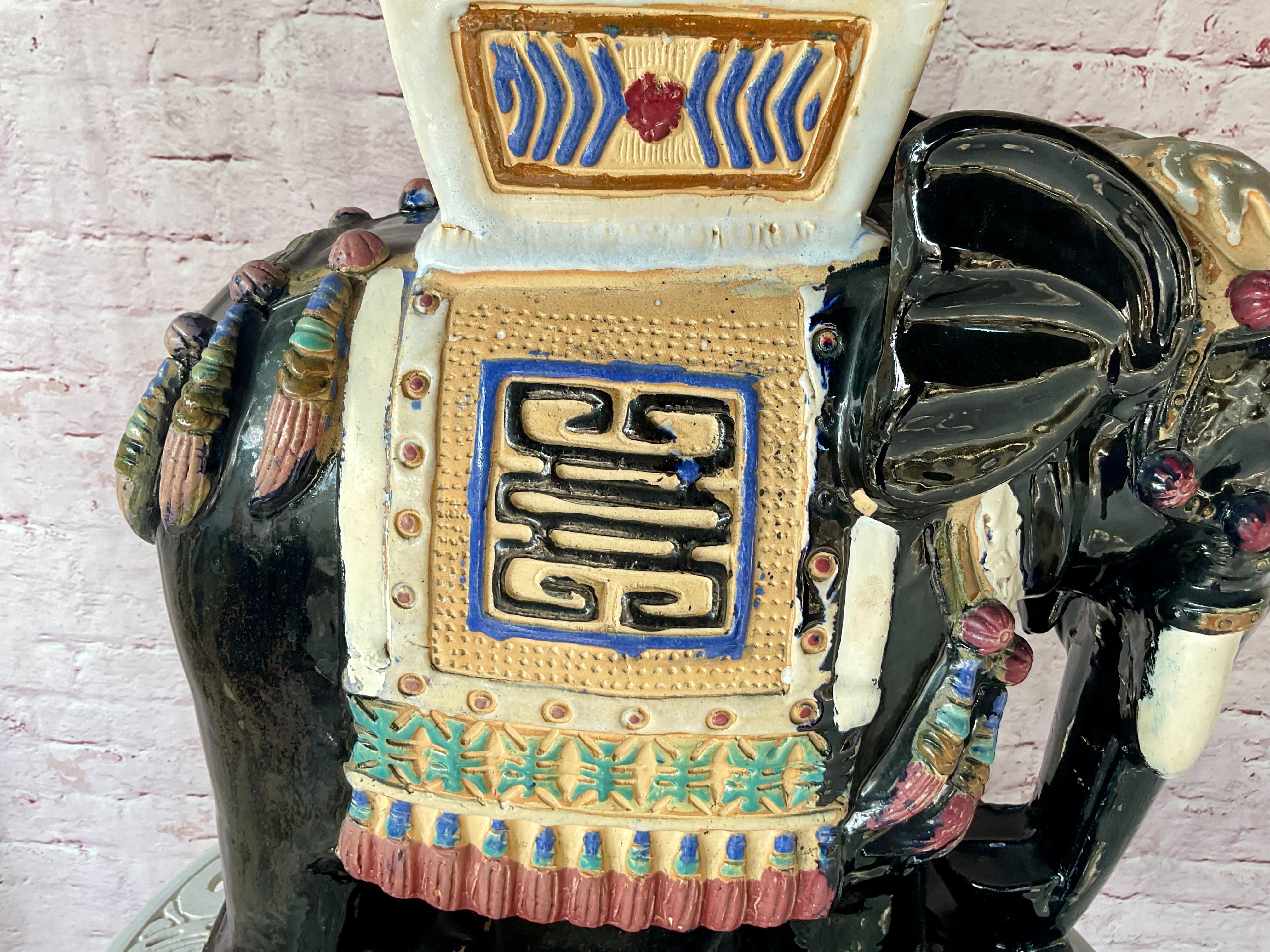 Sgabello da giardino Elefante in ceramica vintage del 20° secolo. Lo sgabello pesante è dipinto a mano nella tradizionale tavolozza cinese di nero, crema, rosso, blu e oro.  Questo vivace pezzo raffigura un elefante regale in piedi con la proboscide