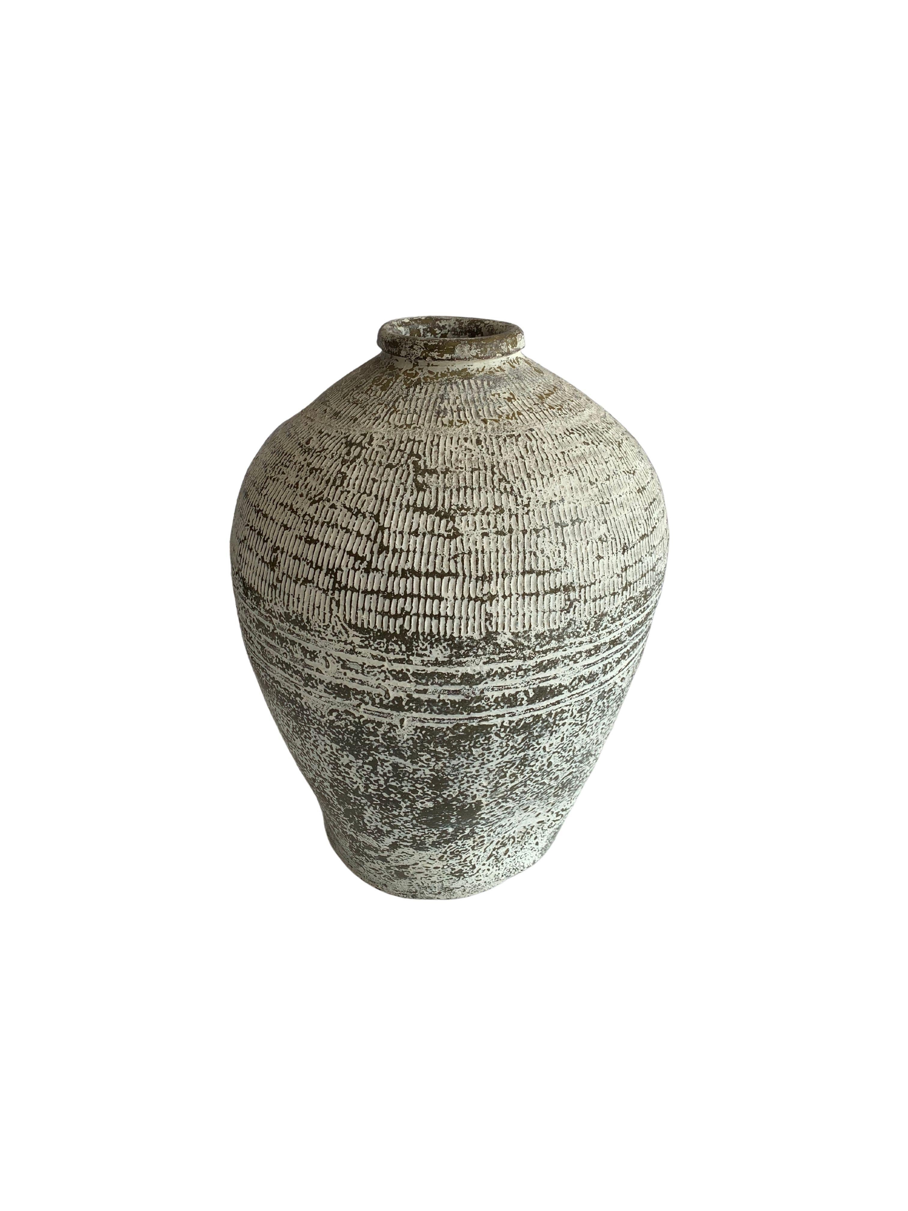 This vintage glazed Chinese ceramic jar from mid 20th Century was once used for pickling foods. It features a jade green finish and outer surface that features a ribbed texture. This jar has been given a newly added washed out white paint finish to