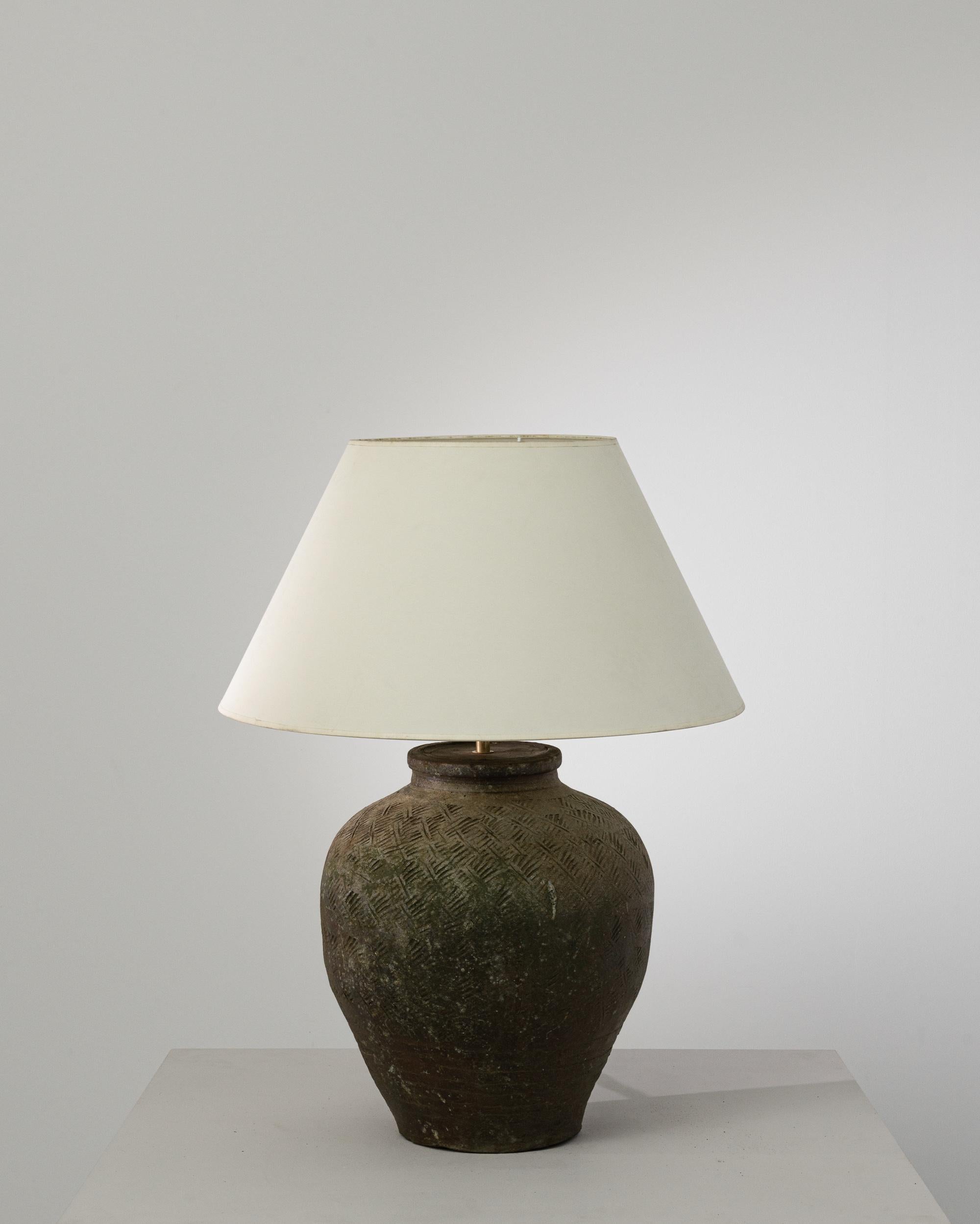 An extraordinary piece to inspire your collection. This vintage Chinese vase has been adapted into a beautiful table lamp. Polished brass meets the seductive warm brown glaze, enlightening your space with an uncompromising contrast. The textured
