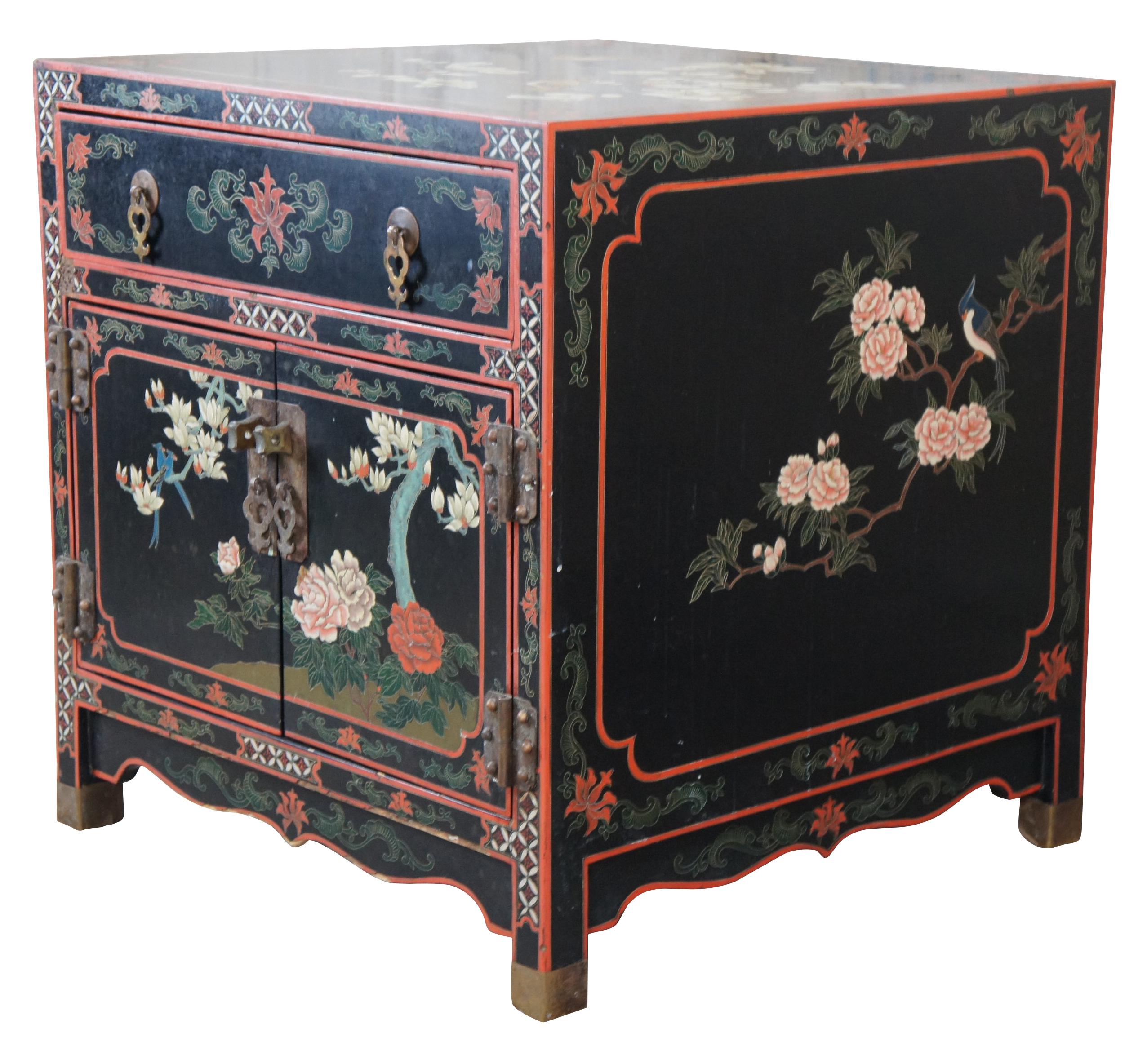 Vintage Chinese black lacquered cabinet side table featuring square form with upper drawer, lower cabinet and a floral bird landscape motif with brass capped feet.. 