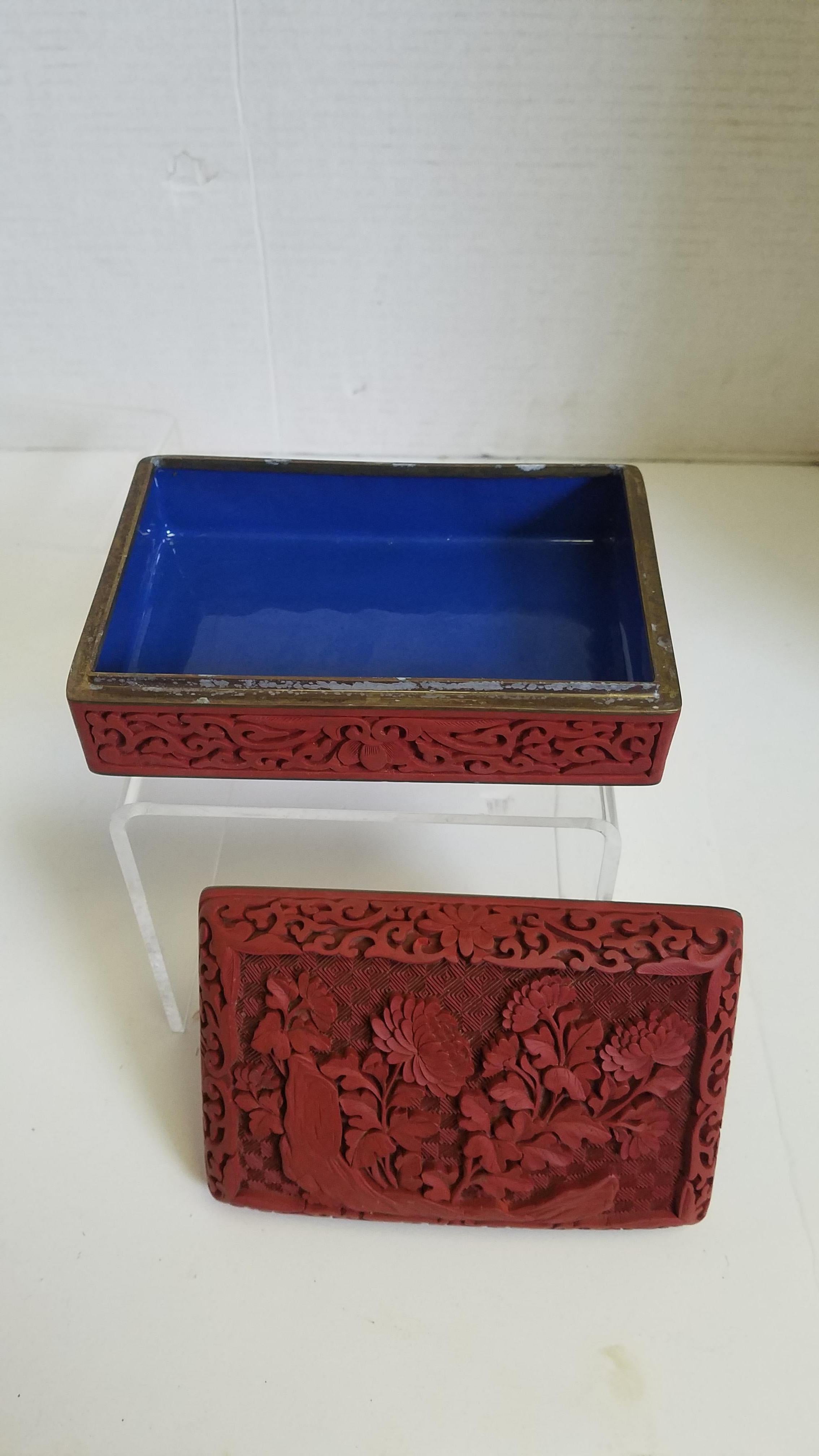 Vintage Chinese Cinnabar box. The foundation of the box is brass and the inside in enameled in a rich blue. The detail of the cinnabar can be see on every surface of the outside, even the bottom. Beautiful floral with relief carving, please see all