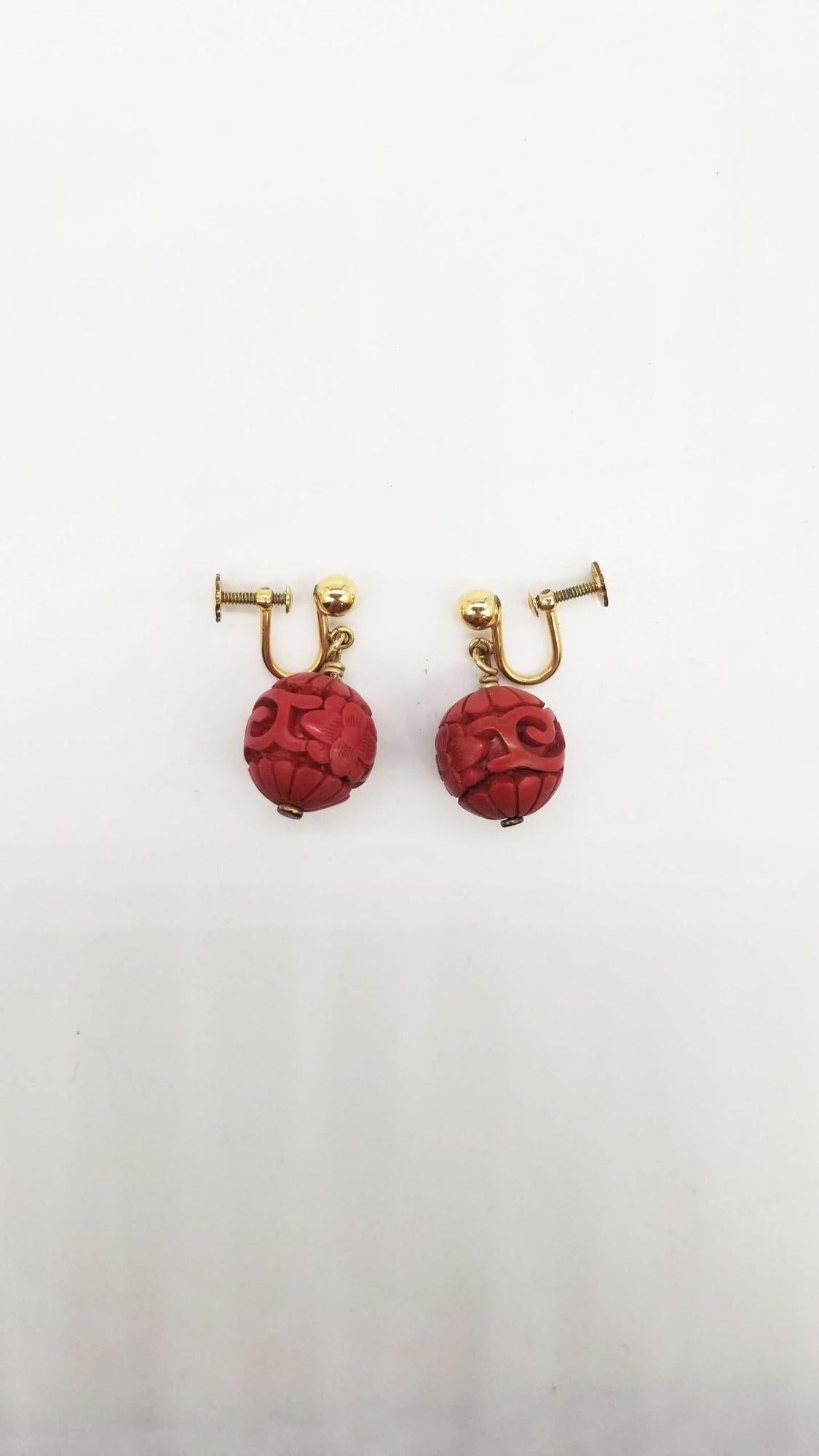 Dieses Set aus chinesischer Perlenkette und Ohrringen besteht aus einem großen Anhänger mit dem Shou-Symbol und verschlungenen roten Perlen mit Blumenmotiven. Das sieht aus wie echte Zinnoberperlen. Es gibt keine Unvollkommenheiten in den