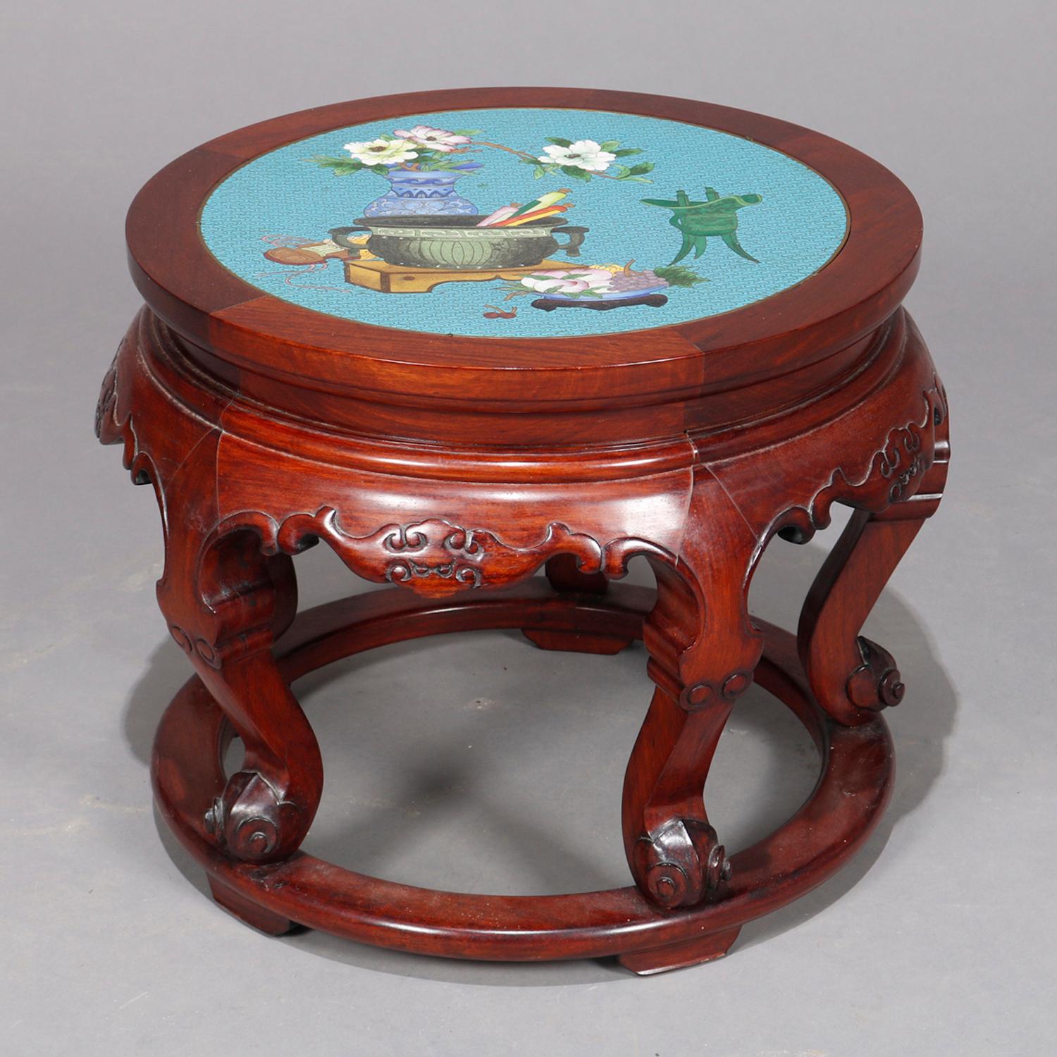 A vintage Chinese low table offers Cloisonné inset top having floral and urn decoration seated in carved mahogany base with shaped skirt raised on cabriole legs, 20th century.


Measures: 14