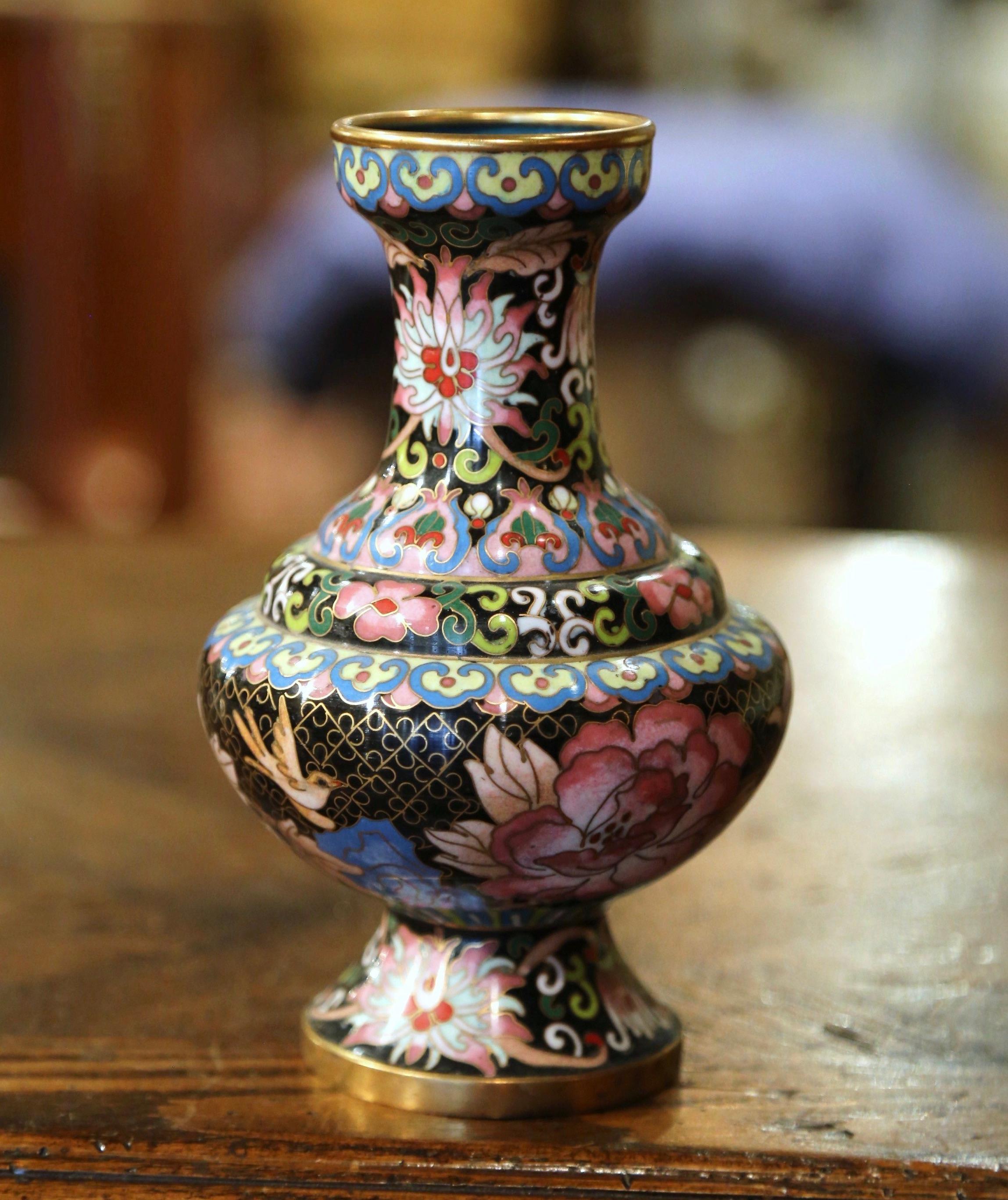 Decorate a table or a buffet with this colorful baluster vase. Created in China circa 1980, the vase features floral and scroll motifs in the cloisonné technique (decorative work in which enamel, glass, or gemstones are separated by strips of