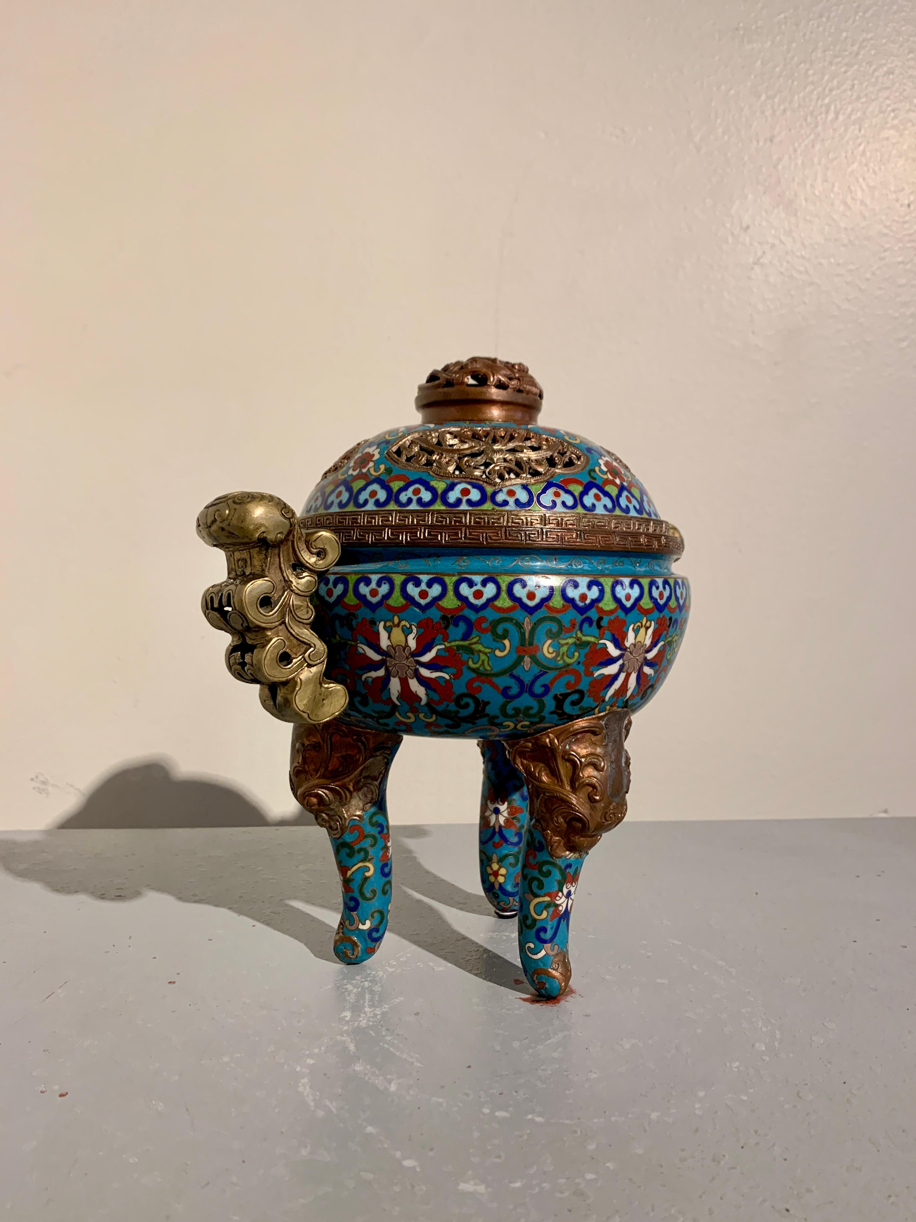A delightful vintage Chinese cloisonne enamel, copper, and brass tripod censer with pierced cover, circa 1970's, China.

The censer with a globular body set on three gracious cabriole legs emerging from copper masks of horned mythical beasts,