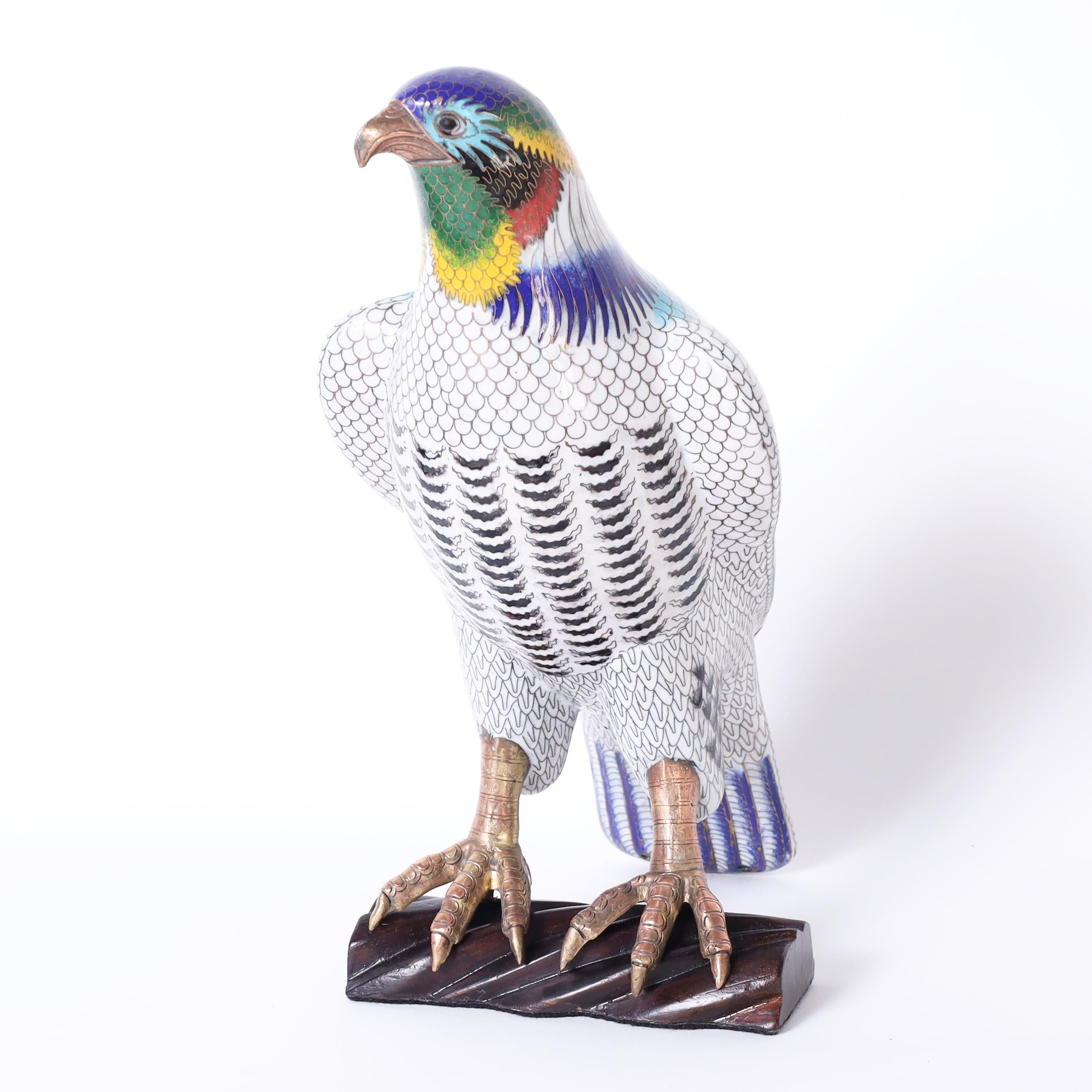 Standout near life size Chinese cloisonne or enamel on copper bird of prey ambitiously decorated in a feather motif and presented on a wood base. 