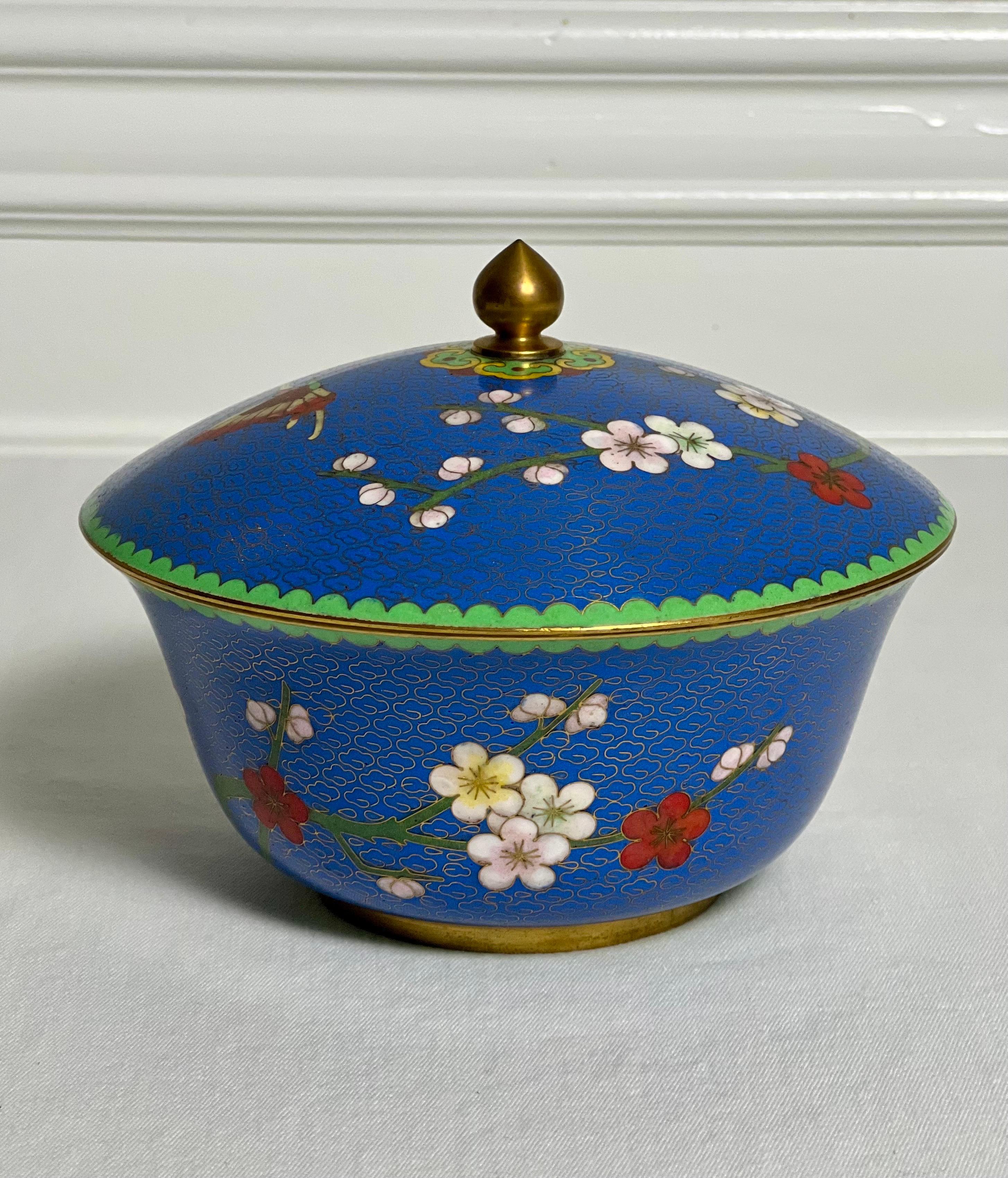 Una straordinaria scatola o ciotola cinese con coperchio rotondo in blu lapis cloisonné, primi anni '80. Decorato in modo vivace con un bordo verde, fiori di ciliegio ombreggiati, una singola farfalla, accenti dorati e un intricato disegno sul