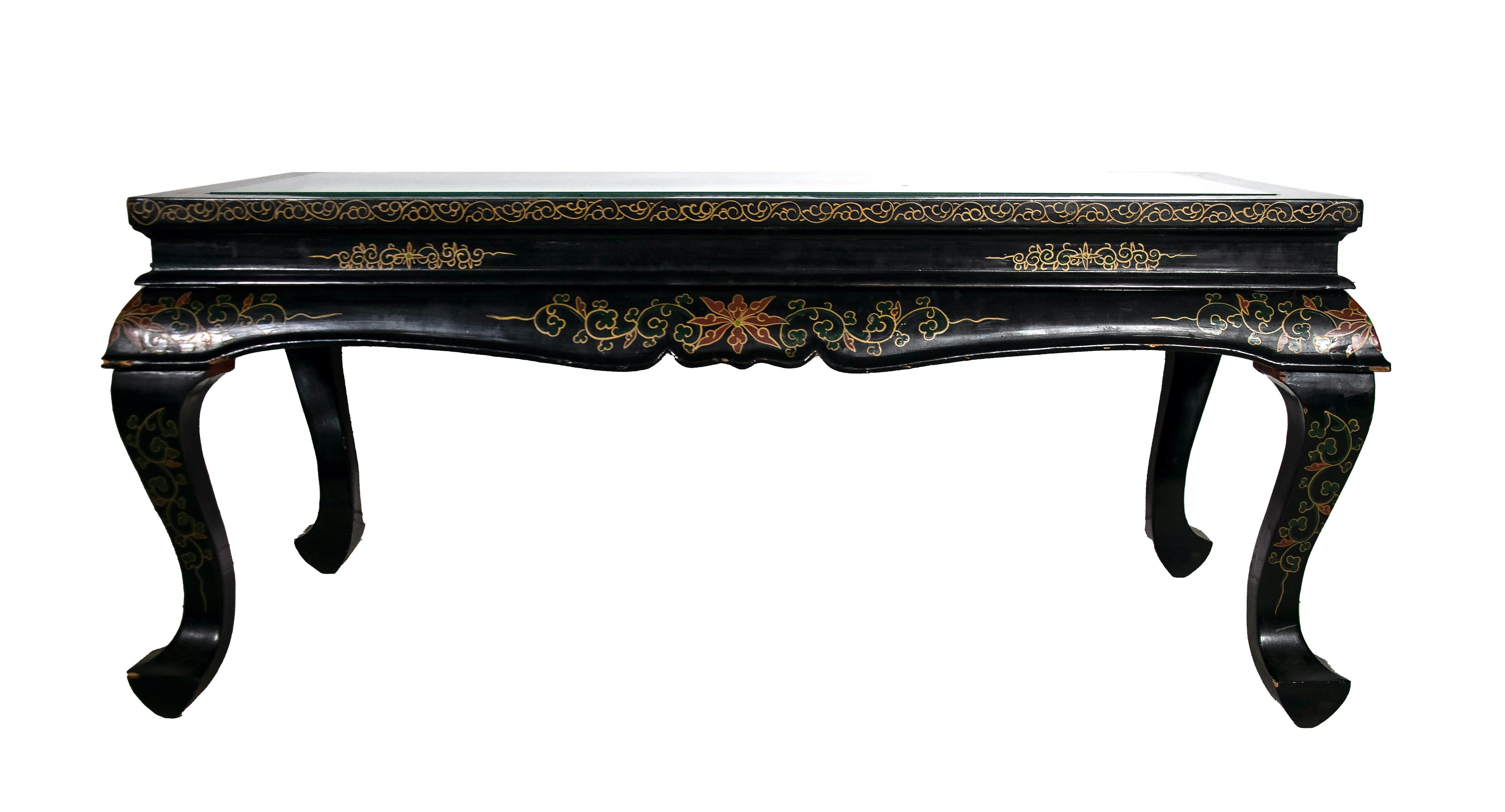 This Chinese coffee table is a precious table realized in the early to mid-20th century.

The table is on curved legs, black lacquered ebany wood, floral painted and decorated with mother of pearl inlays, a relief image made of jade and other
