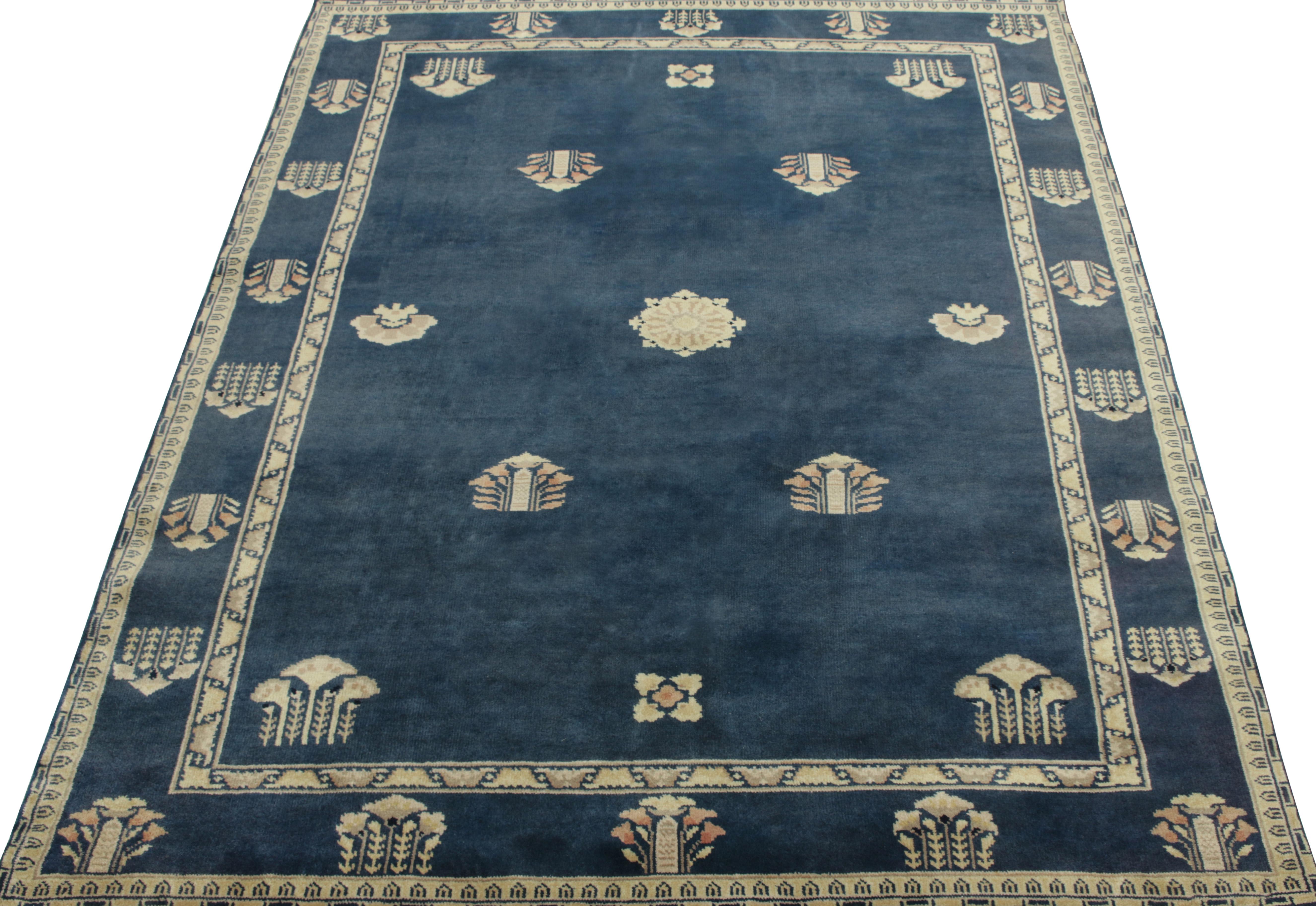A 5 x 7 vintage rug exemplifying Chinese Deco sensibilities, featuring intricate floral patterns on field & border alike in tones of cream, light red & grey on a lush blue background inviting an enticing play of light. Hand-knotted in a healthy wool