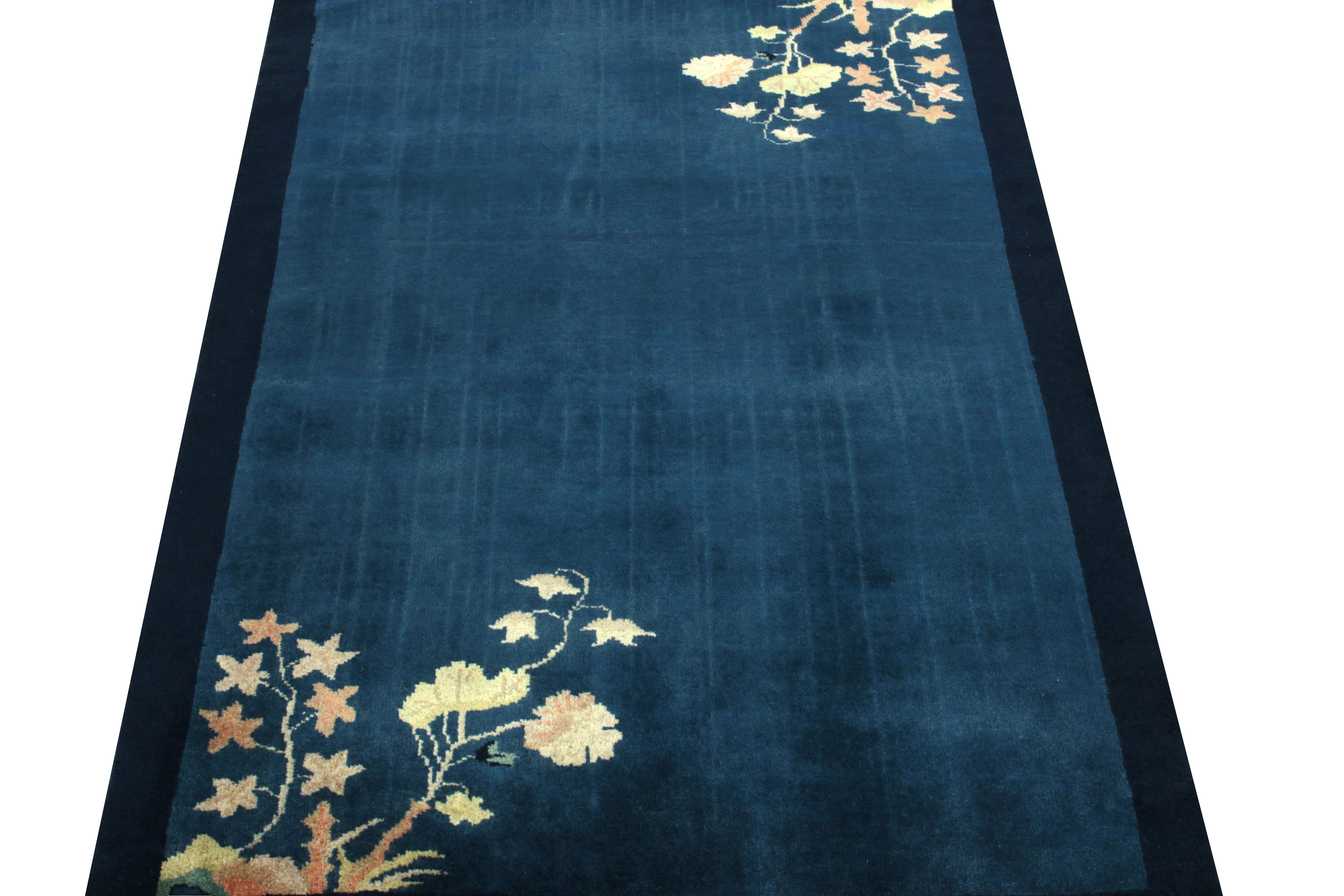 Favouring a swaying floral pattern in cream, peach & green tones, a Chinese deco style rug in deep blue observing light-dark spots making an amicable ground for light to play on such a healthy pile. Hand-knotted in lustrous wool circa 1980-1990, a
