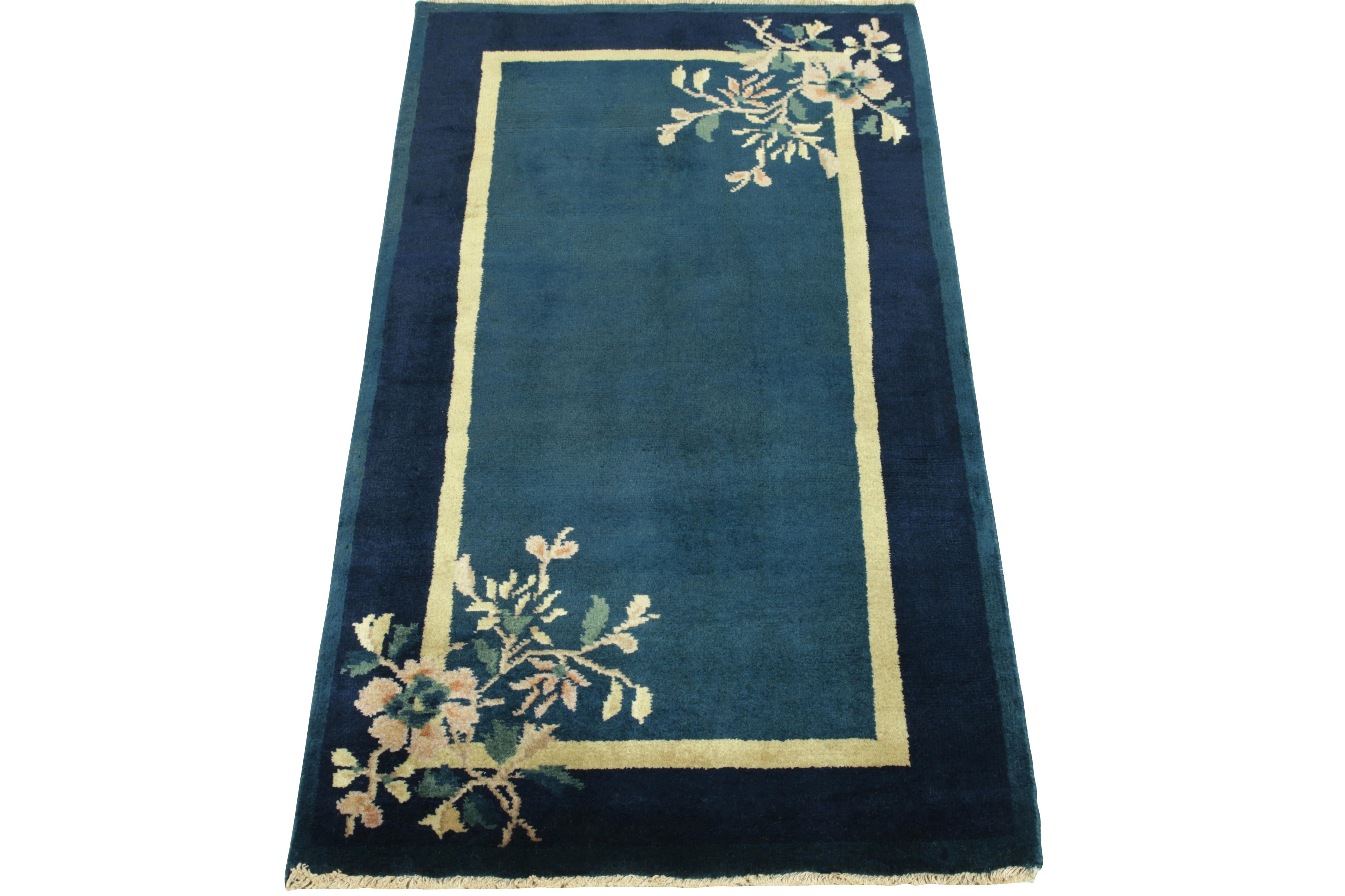 Enjoying blooming florals in teal, salmon & pastel yellow tones in the outer border, a Chinese Deco style vintage rug observing light-dark spots in blue tones connoting a very classic appeal of the 1920s. Further boasting a fine gold border