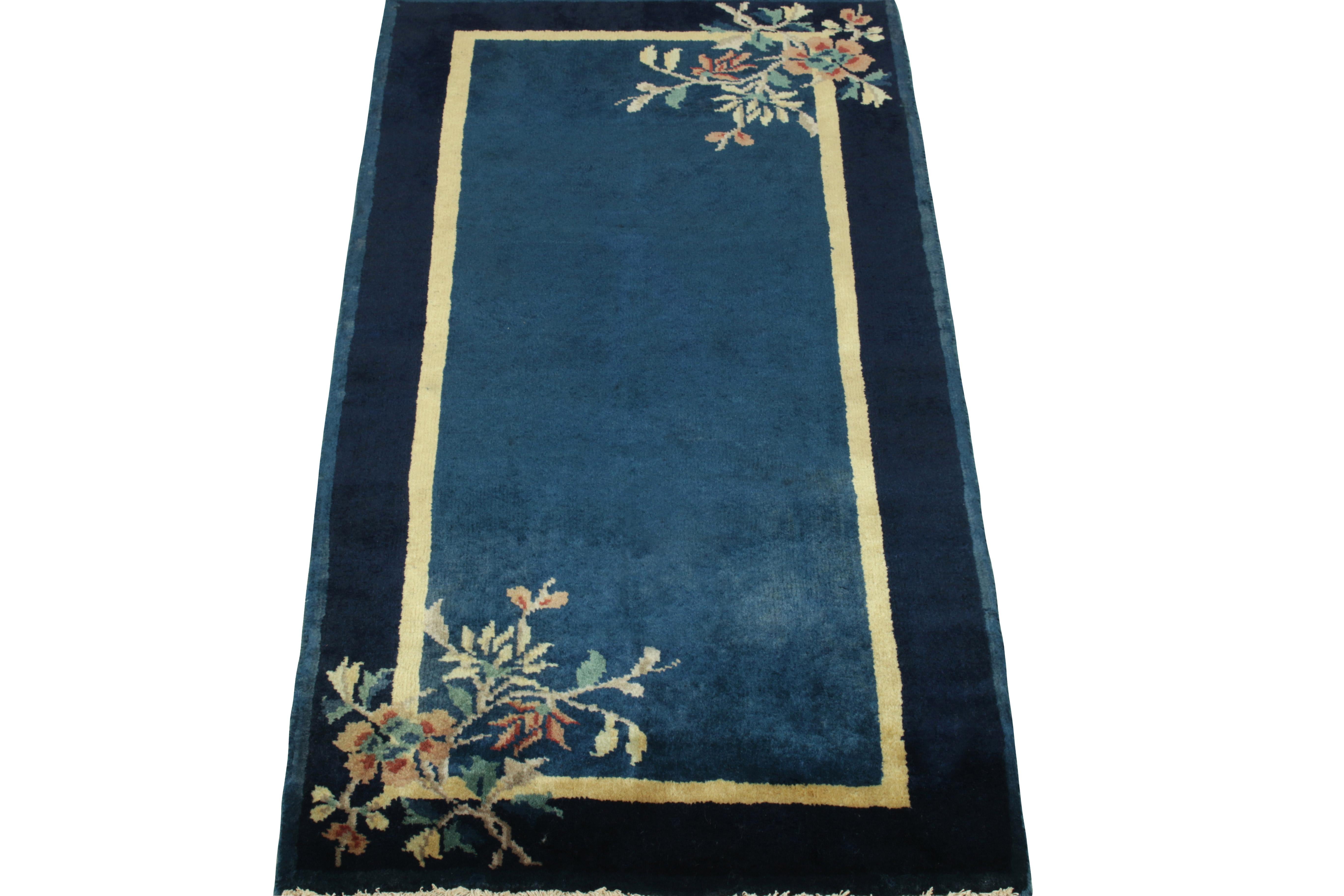 Enjoying a floral pattern in teal, reddish orange & pastel yellow hues in the outer border, a Chinese Deco style vintage rug observing light-dark spots in blue tones connoting a very classic appeal of the 1920s. Further boasting a fine light gold