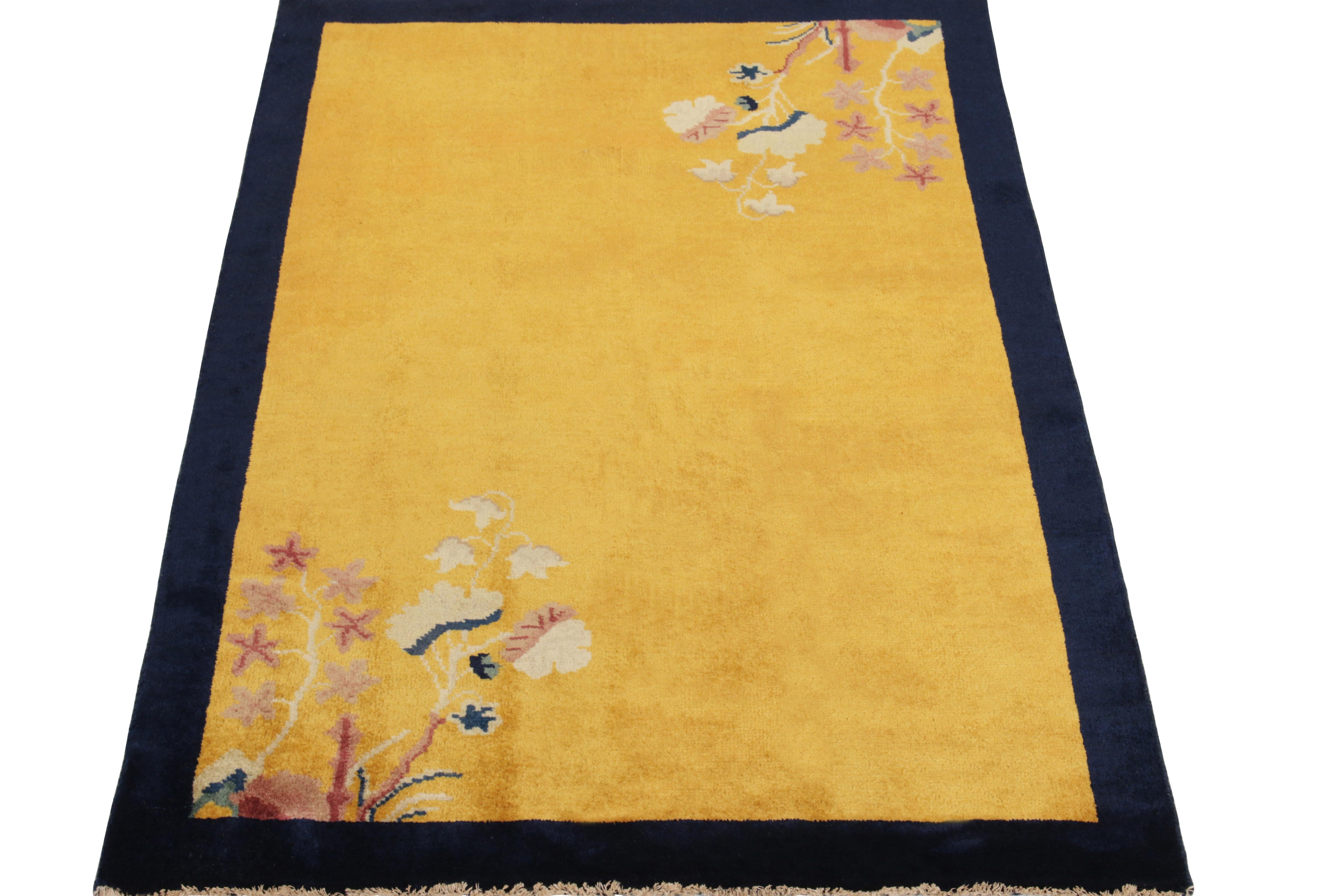 Dieser handgeknüpfte Wollteppich im Format 3x5 ist eine Ode an die chinesischen Art-Déco-Teppiche der 1920er Jahre und zeigt in den diagonalen Ecken der Innenbordüre blühende Blumen in Pastellrosa, Königsblau und Off-White, die den minimalistischen