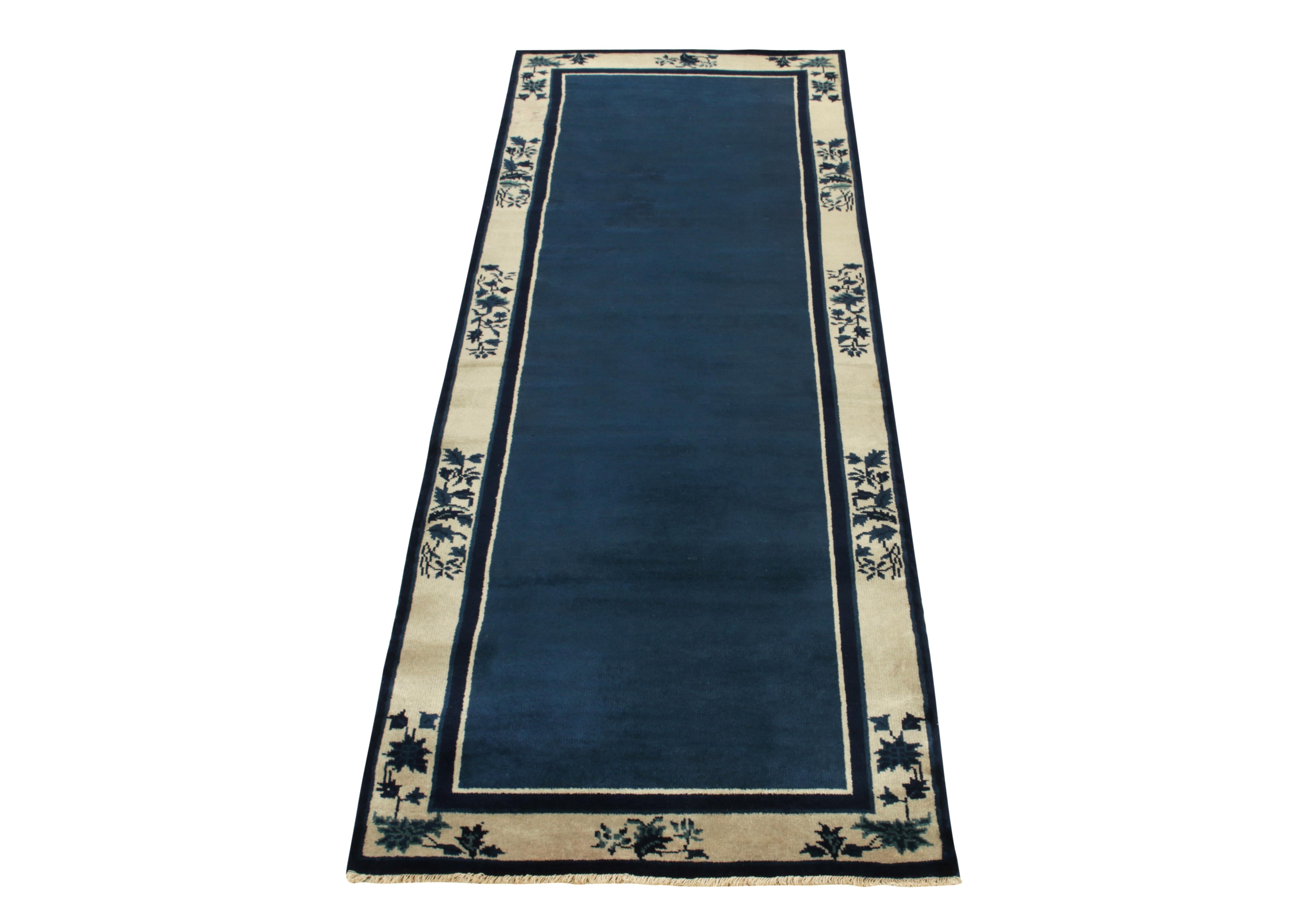 A 3x12 hand-knotted wool vintage runner connoting Chinese art deco sensibilities of the 1920s, coming from Rug & Kilim’s Antique & Vintage collection. The clean blue open field enjoys light dark spots for an interesting visual appeal on scale
