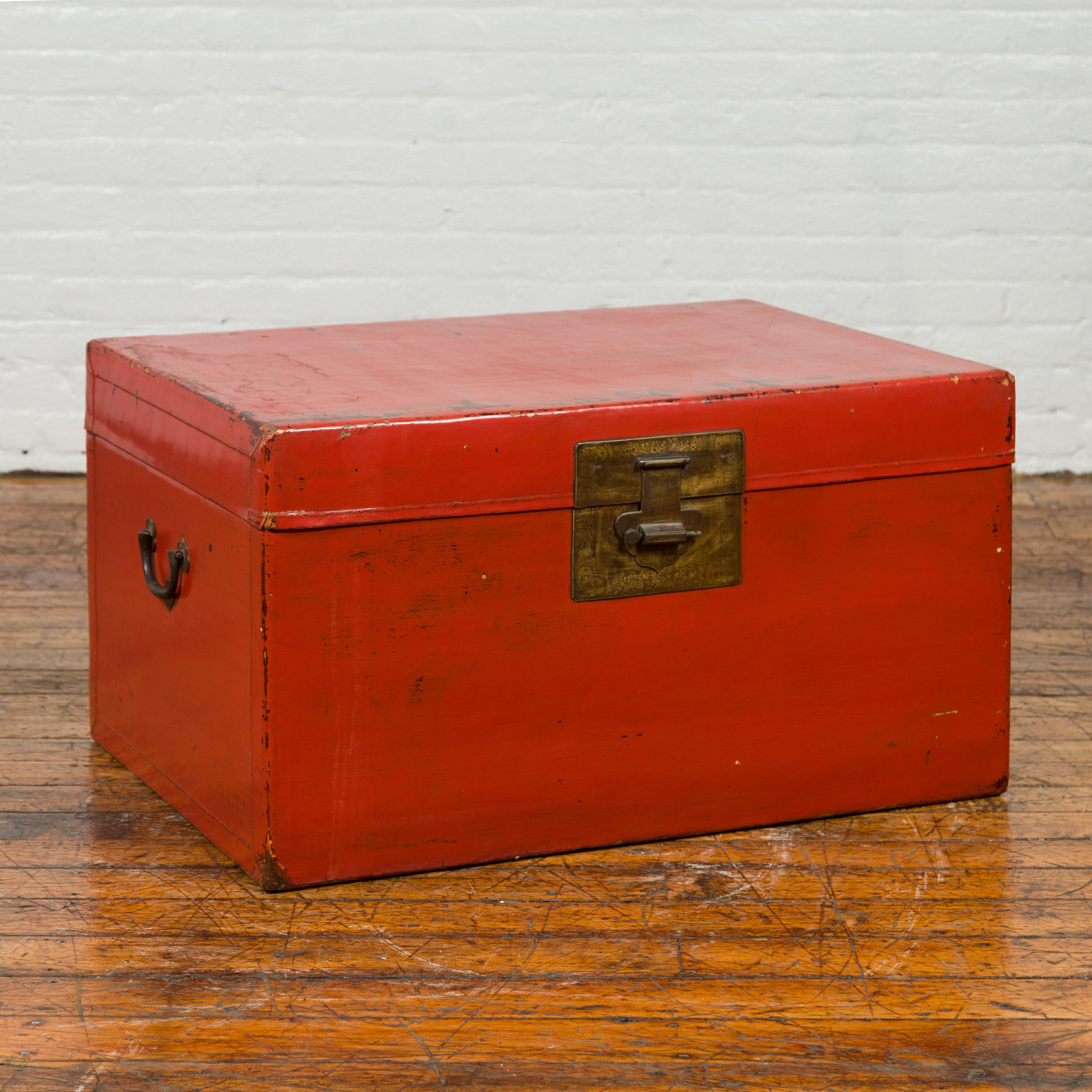 A vintage Chinese red lacquered blanket chest from the mid-20th century with bronze hardware. Created in China during the midcentury period, this blanket chest features a distressed red lacquered finish perfectly complimented by the patinated bronze