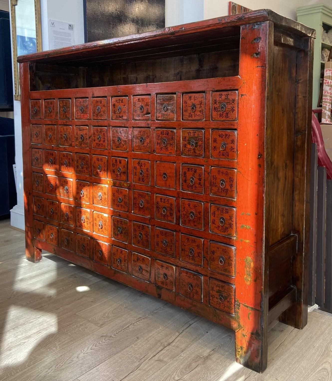 Esempio di artigianato d'epoca, questa cassettiera dipinta a mano è dotata di sessanta cassetti, ognuno dei quali è meticolosamente dettagliato con scritte in cinese che mettono in mostra l'abilità artistica e l'eredità culturale dell'epoca.